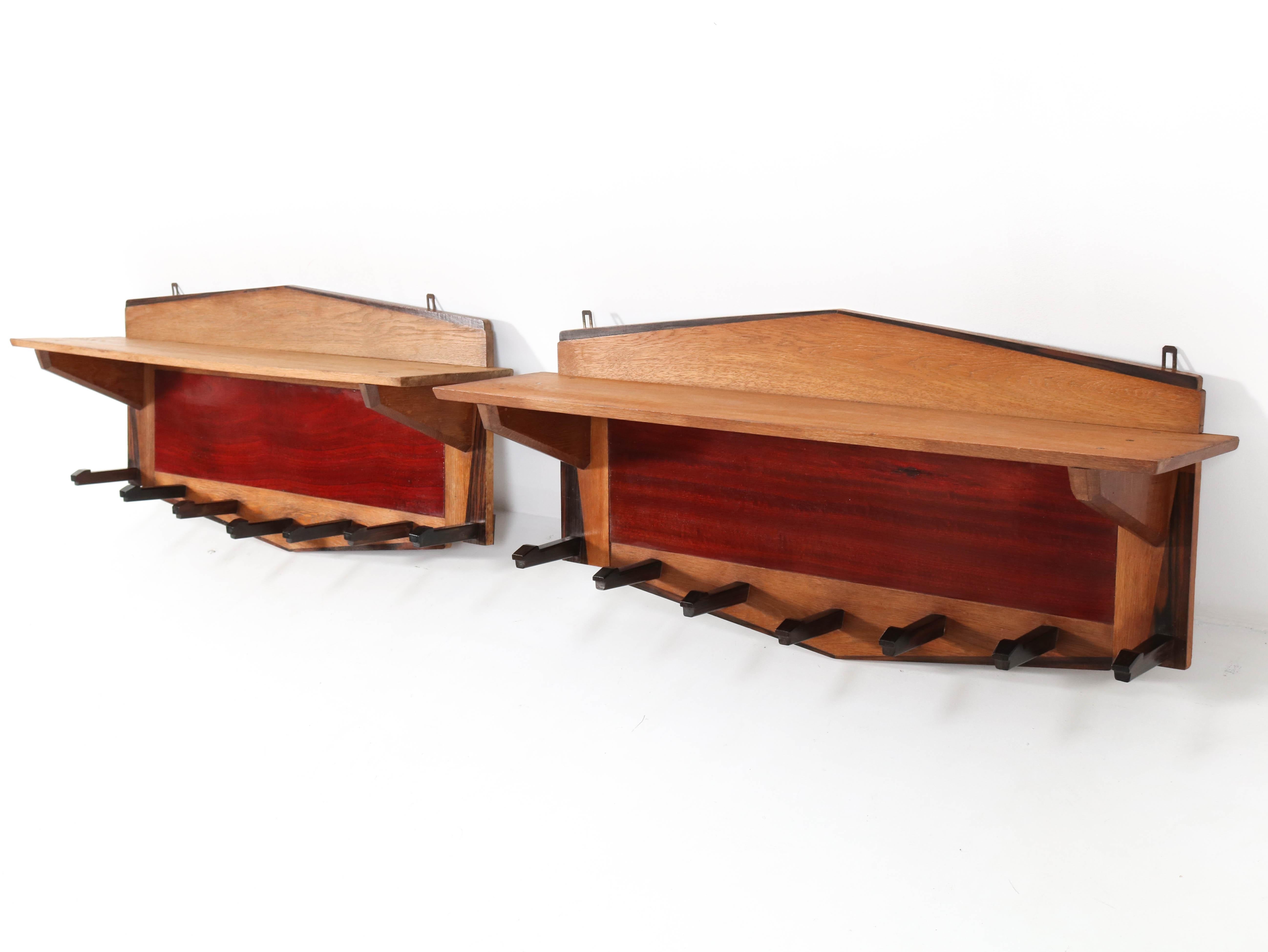 Wonderful and rare pair of two Art Deco Amsterdamse School coat racks.
Design by P.E.L. Izeren for Genneper Molen.
Striking Dutch design from the 1920s.
Solid oak with padouk and solid macassar hooks.
Marked with manufacturers paper label.
In