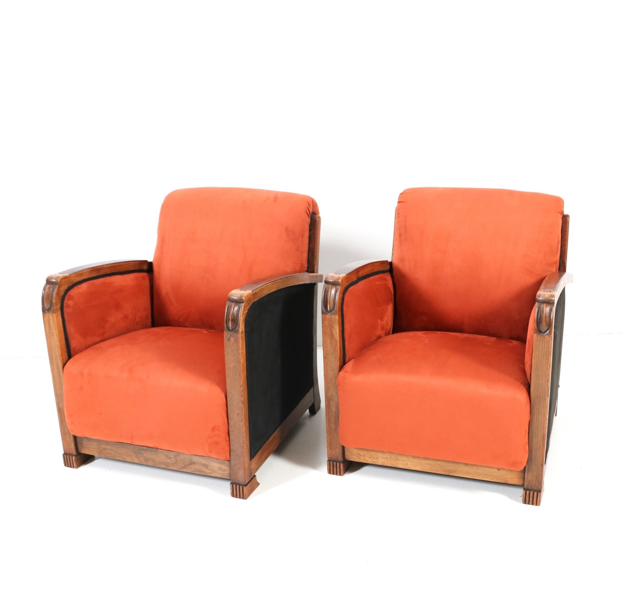 Stunning and rare pair of Art Deco Amsterdamse School lounge chairs.
Striking Dutch design from the 1920s.
Solid oak frames with solid macassar ebony armrests.
Original hand-carved stylish birds at the end of the armrests.
Re-upholstered with a