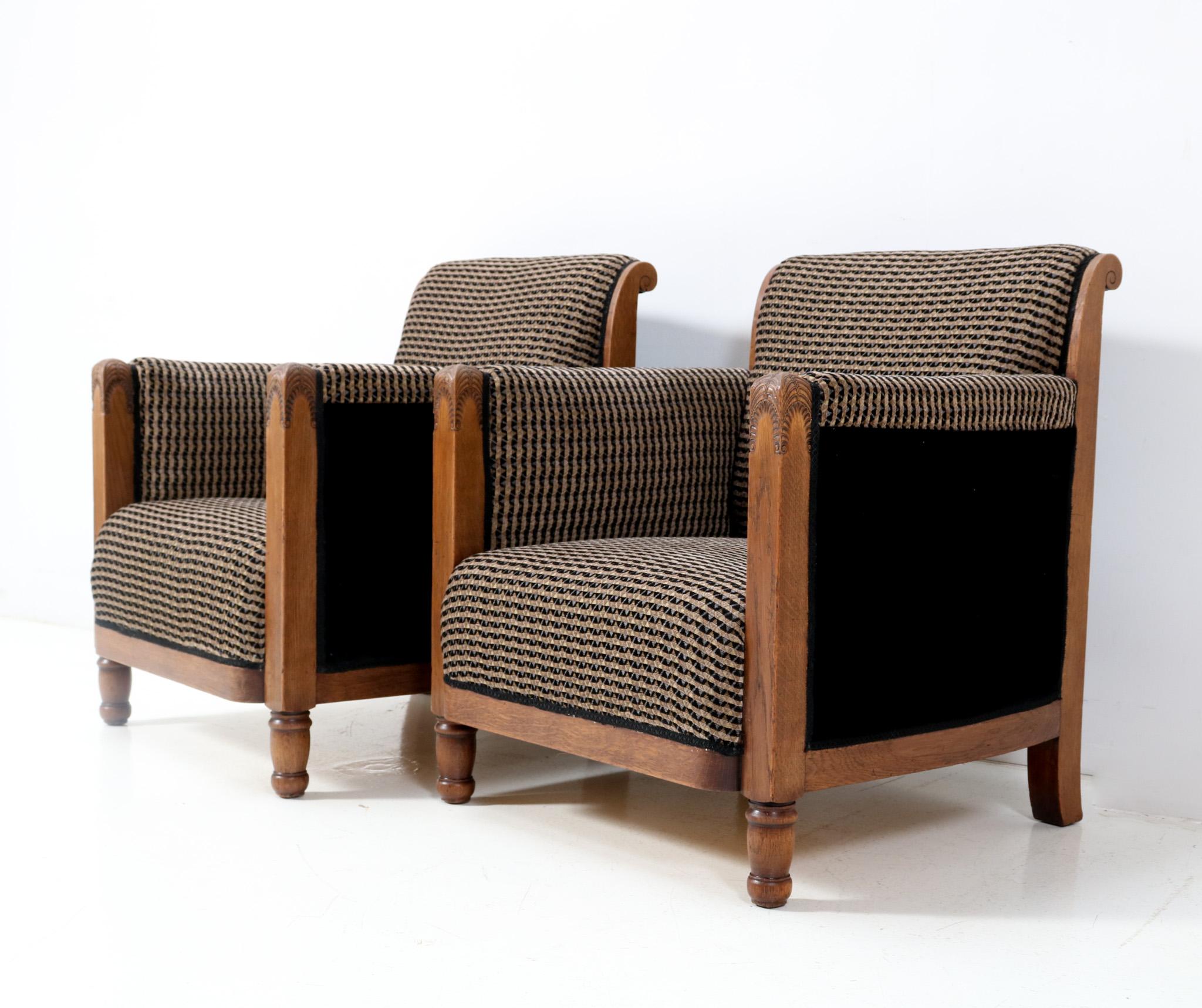 Magnificent and rare pair of Art Deco Amsterdamse School lounge chairs.
The design attributed to Chris Bartels Haarlem.
Striking Dutch design from the 1920s.
Solid oak frames with typical Amsterdamse School style elements.
Re-upholstered with a