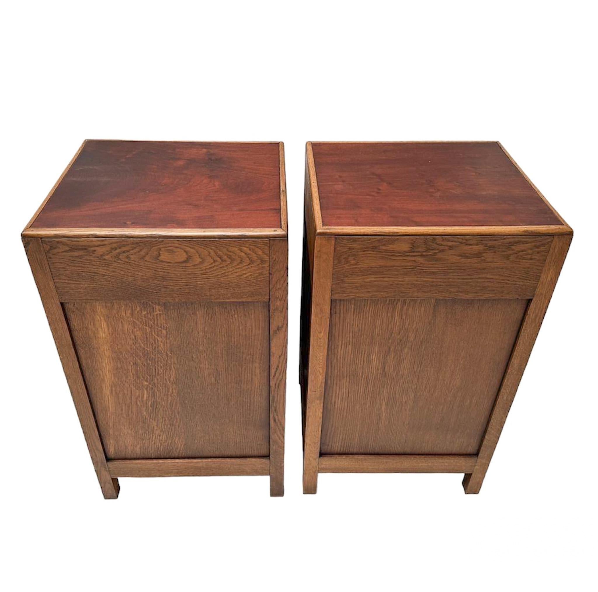 Stunning and rare pair of Art Deco Amsterdamse School nightstands or bedside tables.
Design by Fa. Drenth Den Haag.
Striking Dutch design from the 1920s.
Solid oak base with original solid padouk top.
Marked with original metal manufacturers