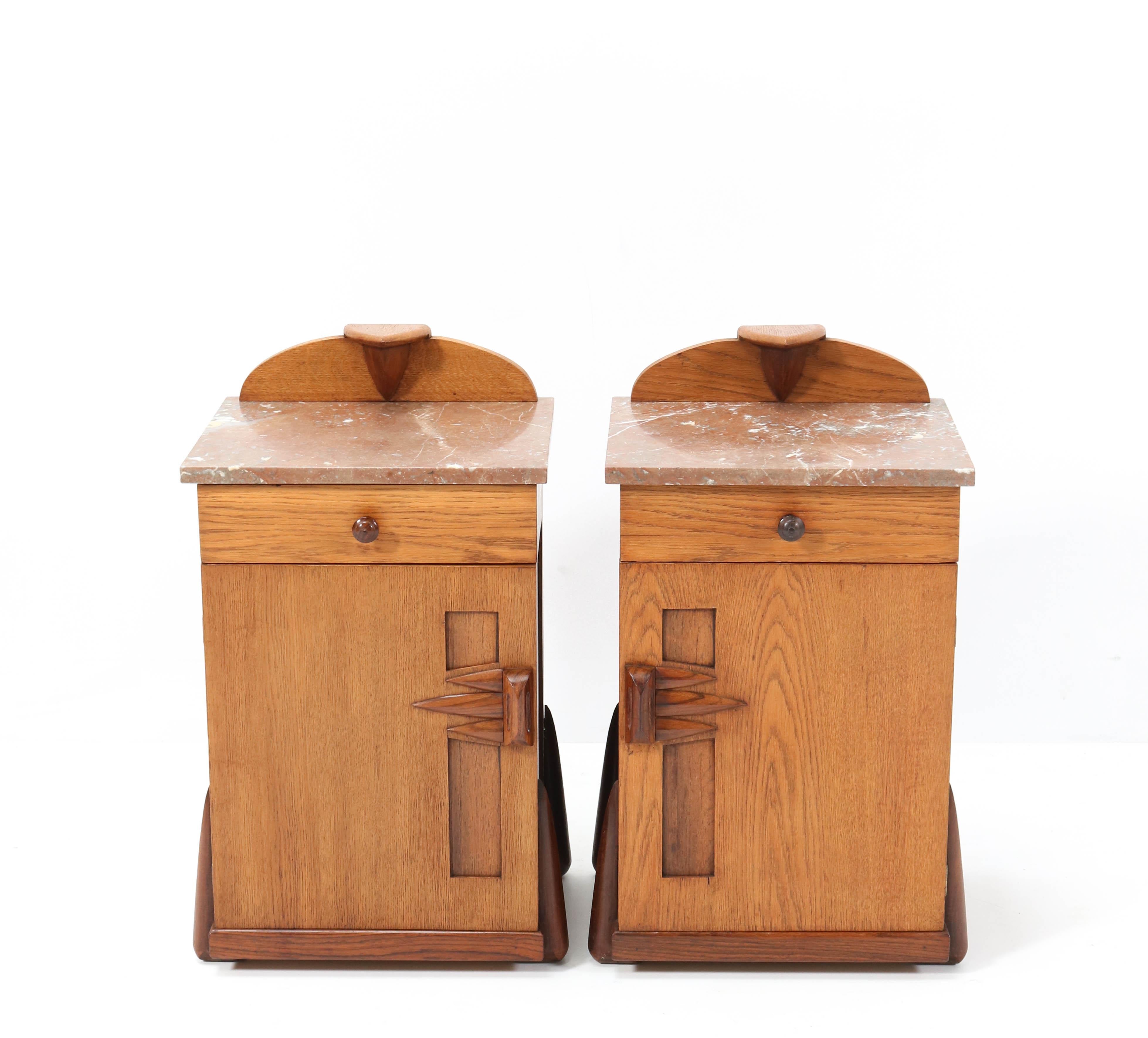 Magnificent and ultra rare pair of nightstands or bedside tables.
Design by Max Coini Amsterdam.
Striking Dutch design from the 1920s.
Solid oak and original oak veneer with solid padouk handles and knobs and lining.
Original multi-colored