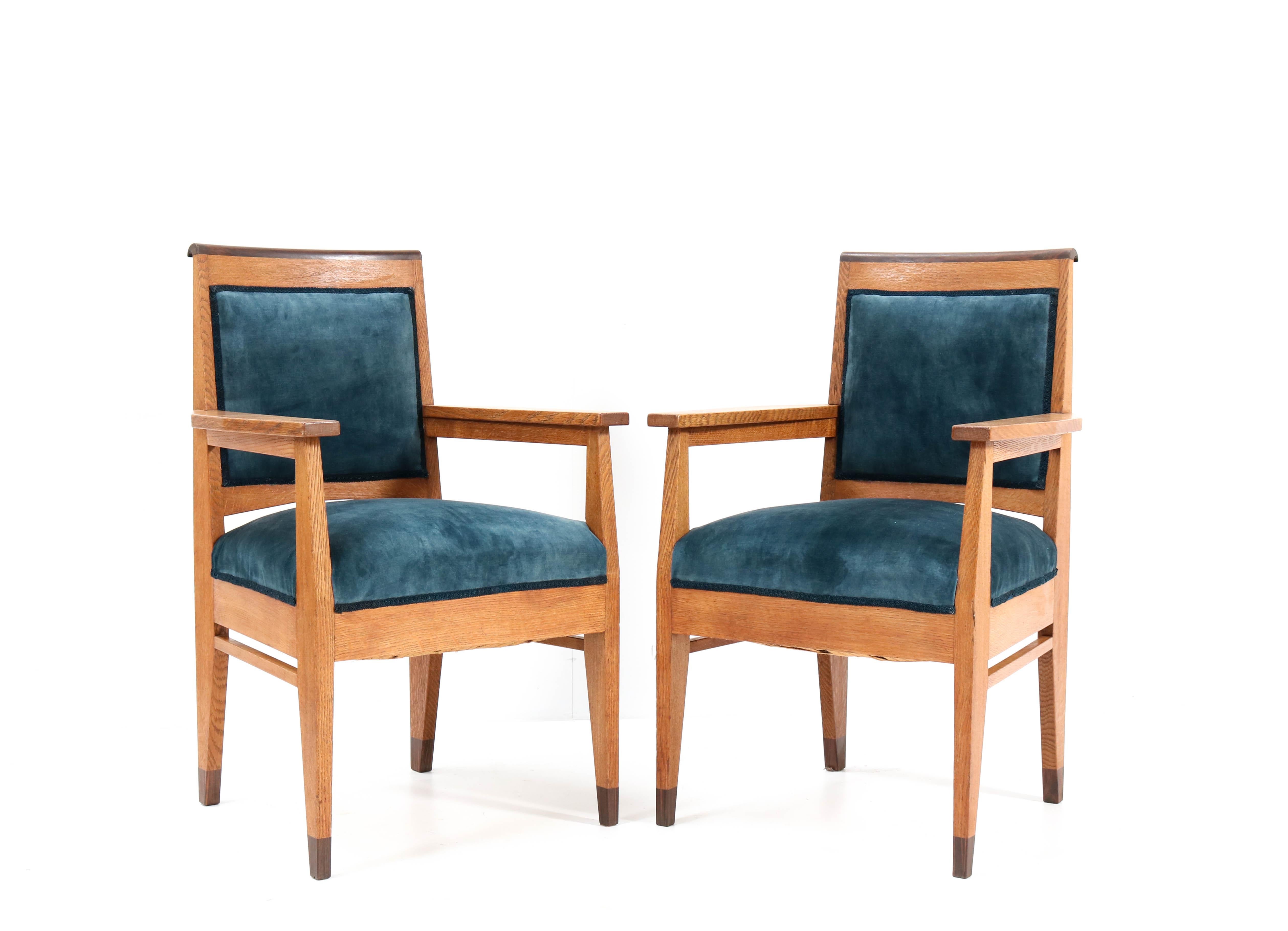 Magnificent and rare pair of Art Deco Haagse School armchairs.
Design by Anton Lucas for N.V. Meubelkunst Leiden.
Striking Dutch design from the 1920s.
Solid oak with solid ebony macassar lining on top of the chairs.
Re-upholstered with petrol