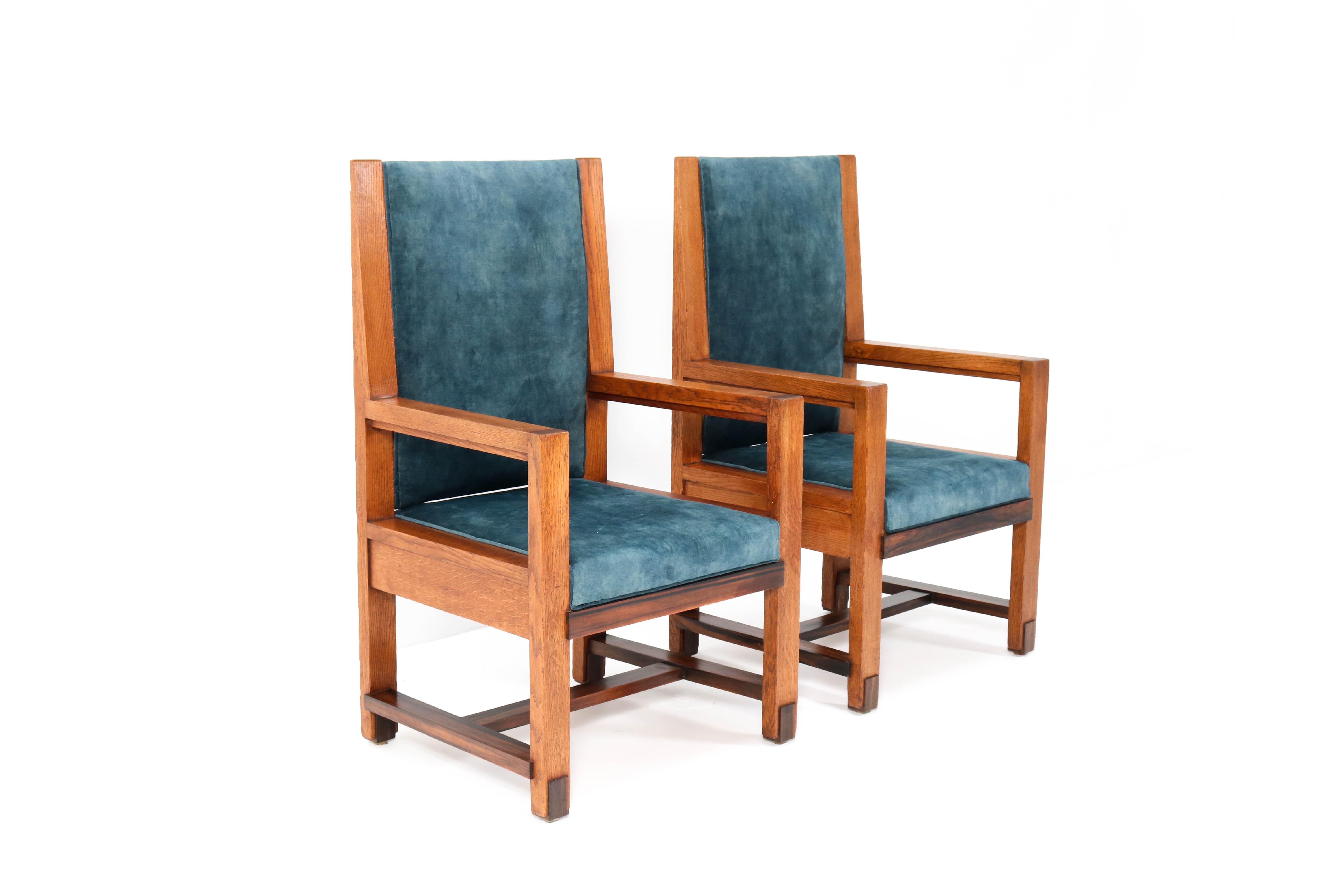 Magnificent and rare pair of two Art Deco Haagse School armchairs.
Design by Henk Wouda for H. Pander & Zonen.
Striking Dutch design from the 1920s.
Solid oak with solid Macassar ebony lining.
Re-upholstered with a petrol blue velvet