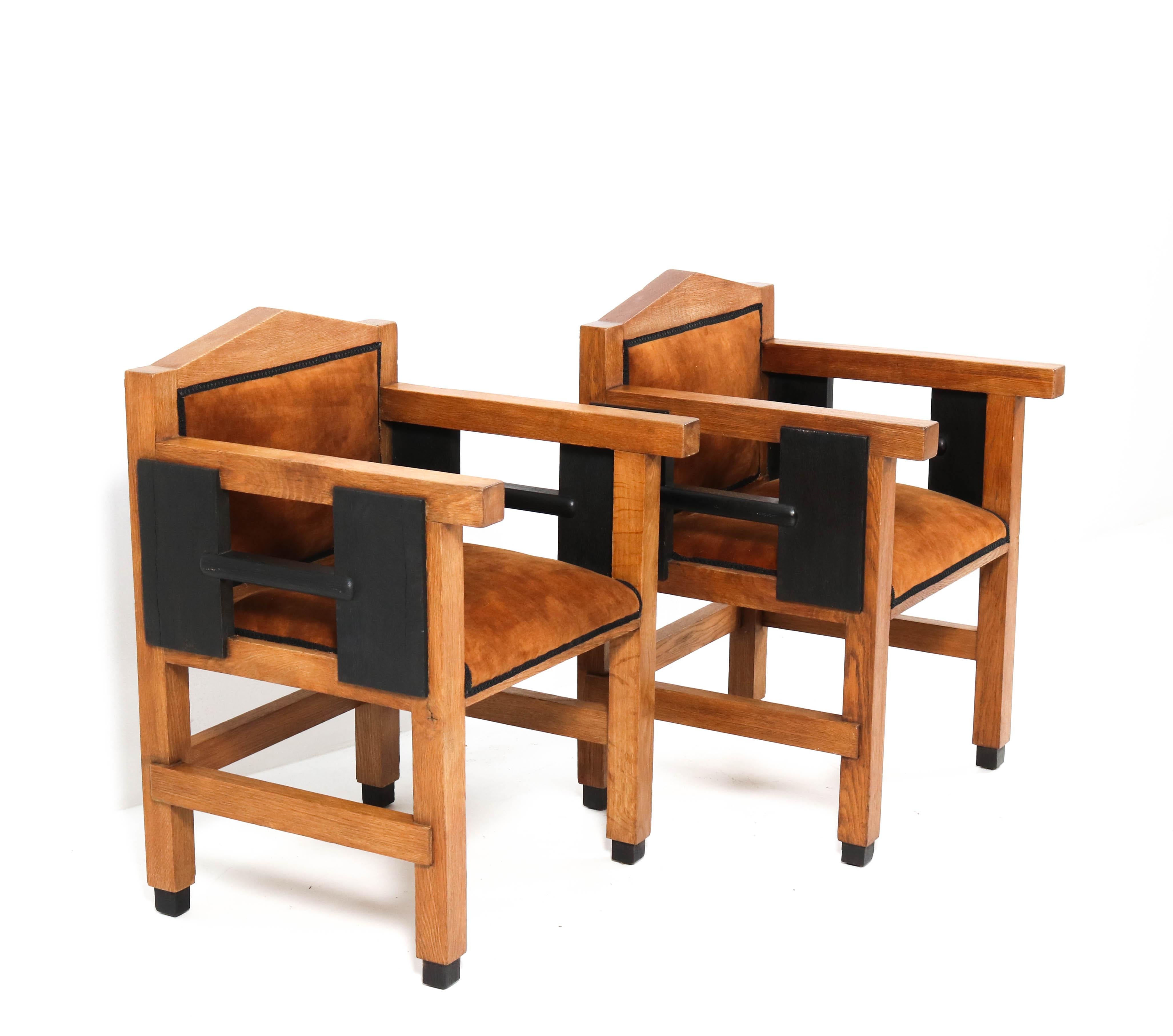 Magnificent and very rare pair Art Deco Haagse School armchairs.
Design by Jacques Grubben.
Striking Dutch design from the 1930s.
Solid oak with original black lacquered details.
Re-upholstered with cognac colored velvet.
These wonderful pieces