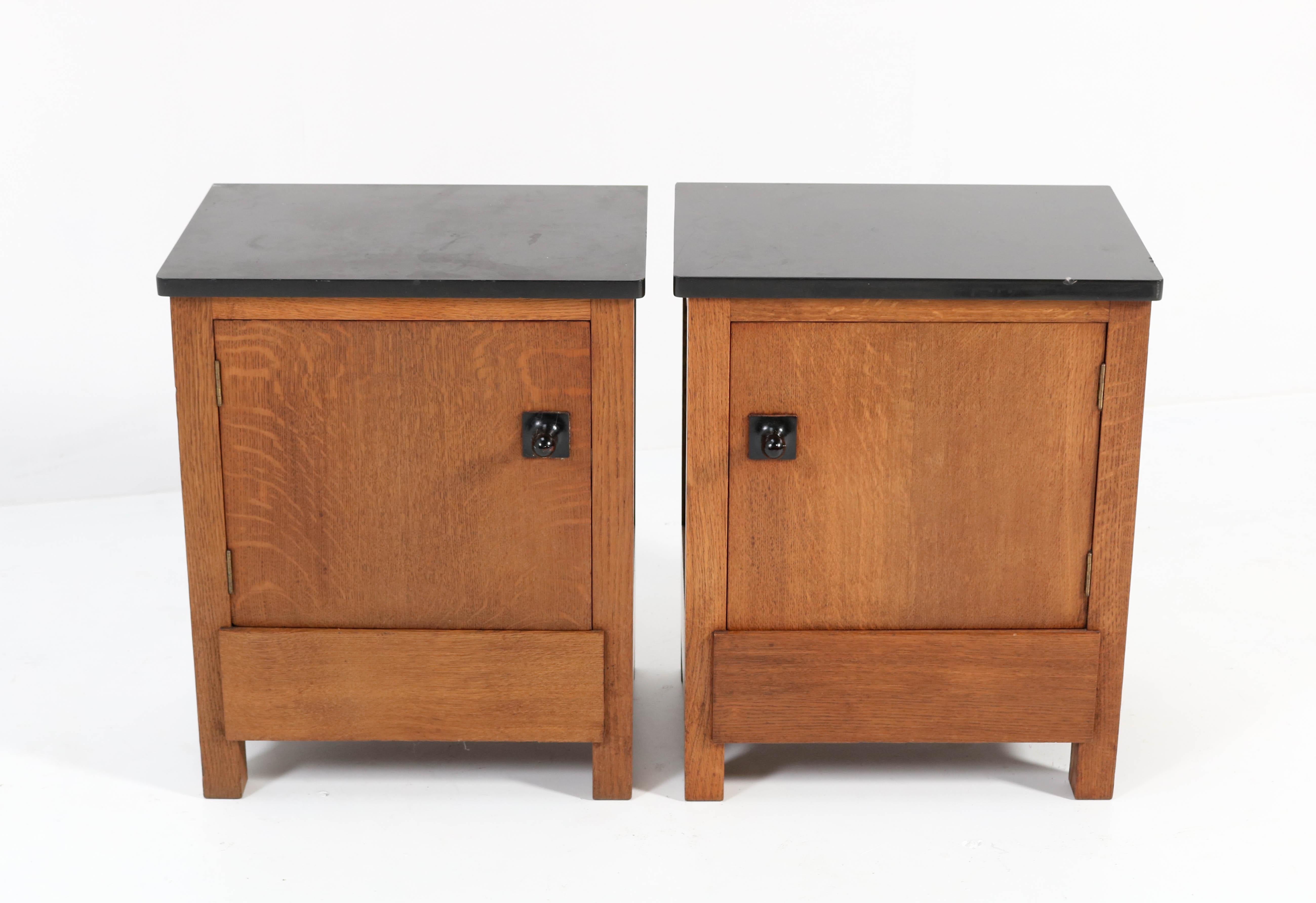 Magnificent and rare pair of Art Deco Haagse School nightstands or bedside tables.
Design by Hendrik Wouda for H. Pander & Zonen.
Striking Dutch design from the twenties.
Solid oak with original black granite tops.
Marked with original manufacturers