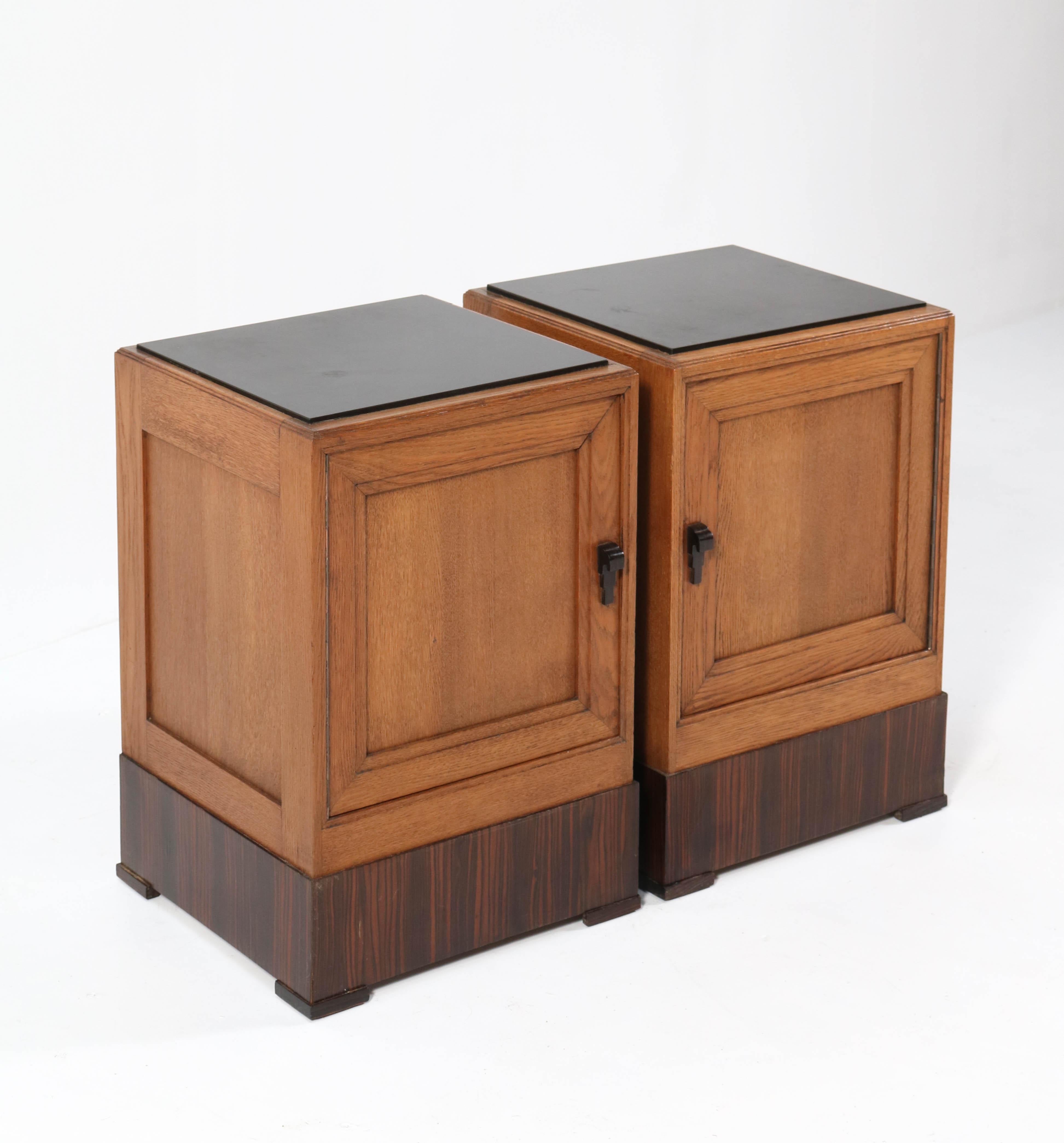 Magnificent and rare pair of Art Deco Haagse School nightstands or bedside tables.
Striking Dutch design from the 1920s.
Solid oak with solid Macassar ebony handles.
Original black granite tops.
This pair of high quality is in very good