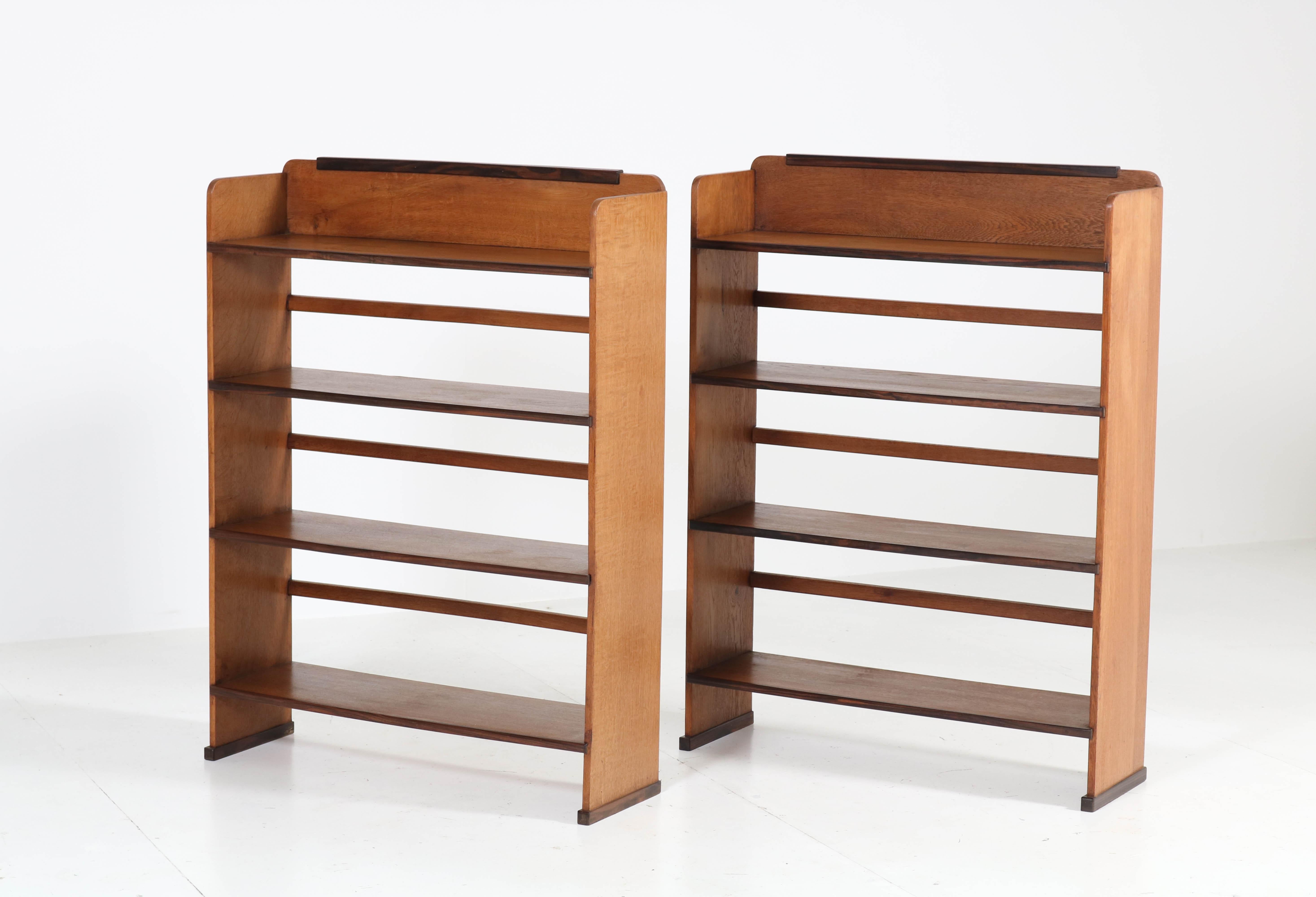 Wonderful and rare pair of Art Deco Haagse School open bookcases.
Design by P.E.L. Izeren for Genneper Molen.
Striking Dutch design from the 1920s.
Oak with Macassar ebony lining.
One of the bookcases is marked with manufacturers label and