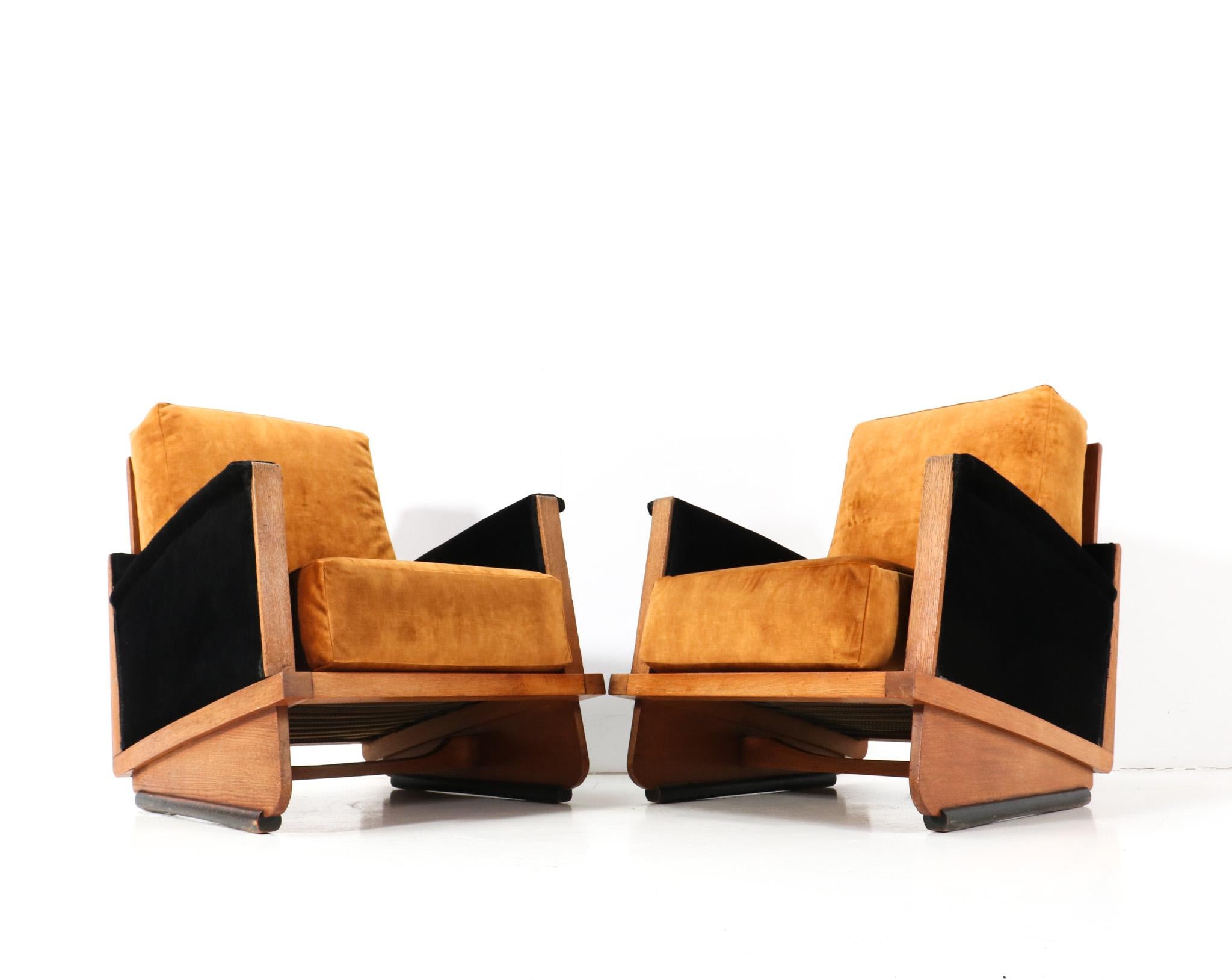 Magnificent and rare pair of Art Deco Modernist lounge chairs.
Striking Dutch design from the 1920s.
Solid oak frames on original black lacquered feet.
Re-upholstered with a quality two-tone fabric.
In very good original condition with minor