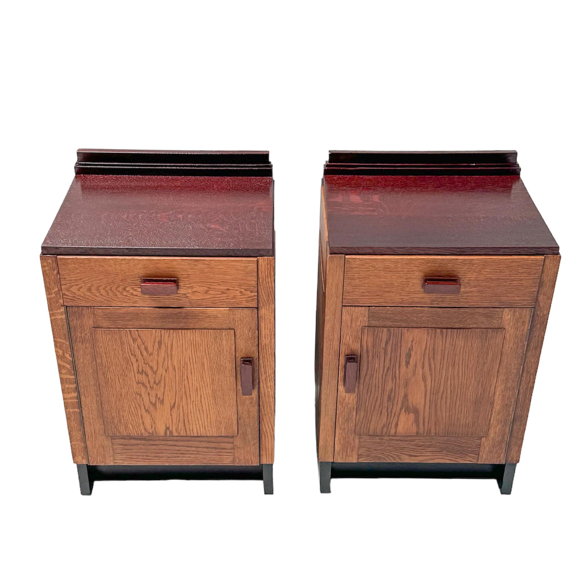 Stunning and rare pair of Art Deco Modernist nightstands or bedside tables.
Striking Dutch design from the 1920s.
Solid oak bases with original red lacquered tops and handles on doors and drawers.
This wonderful pair is in very good original