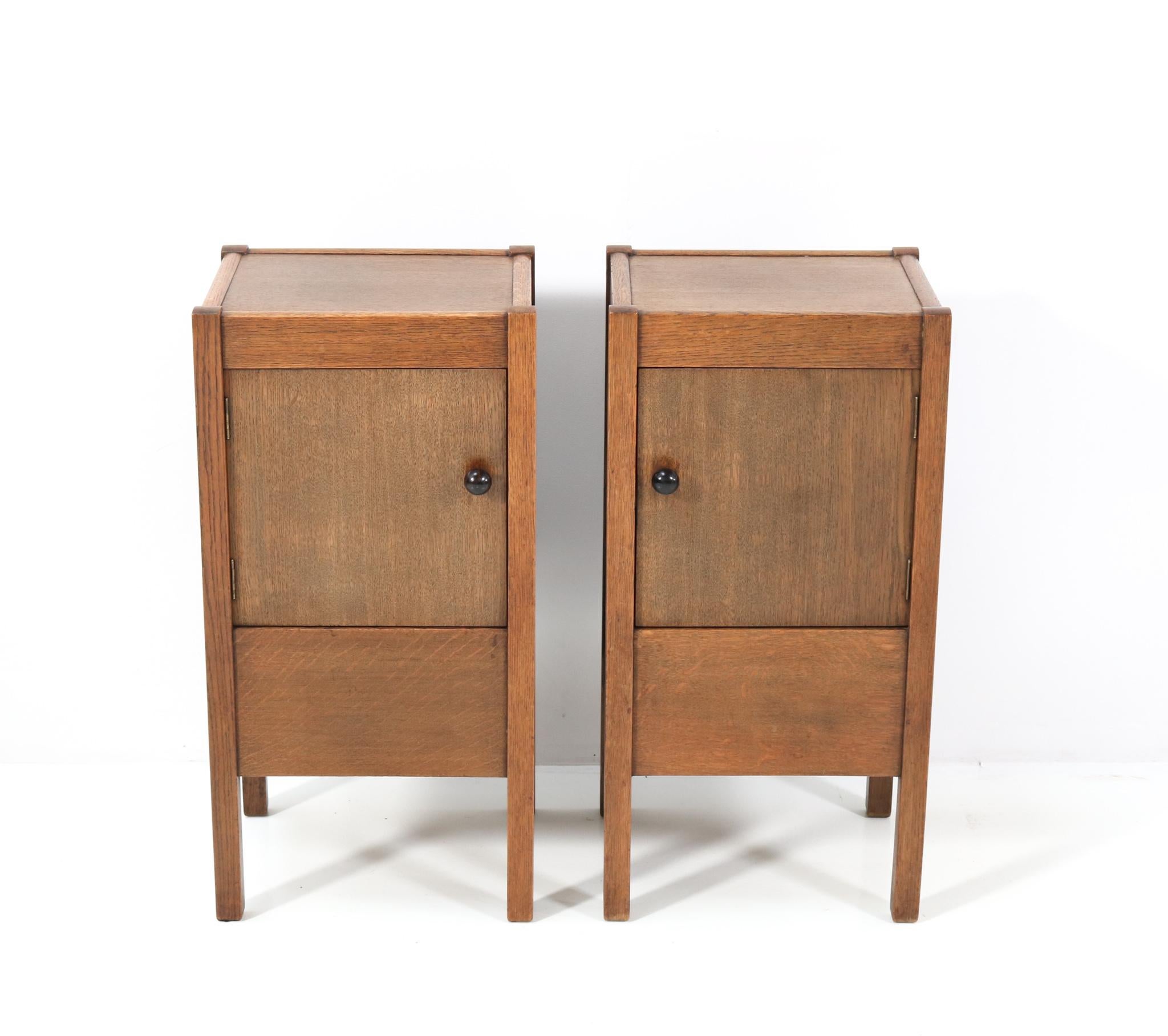 Magnificent and rare pair of Art Deco Haagse School nightstands or bedside tables.
Design by J.A. Muntendam for L.O.V. Oosterbeek.
Striking Dutch design from the 1920s.
Solid oak with original solid macassar ebony knobs on the doors.
Marked with