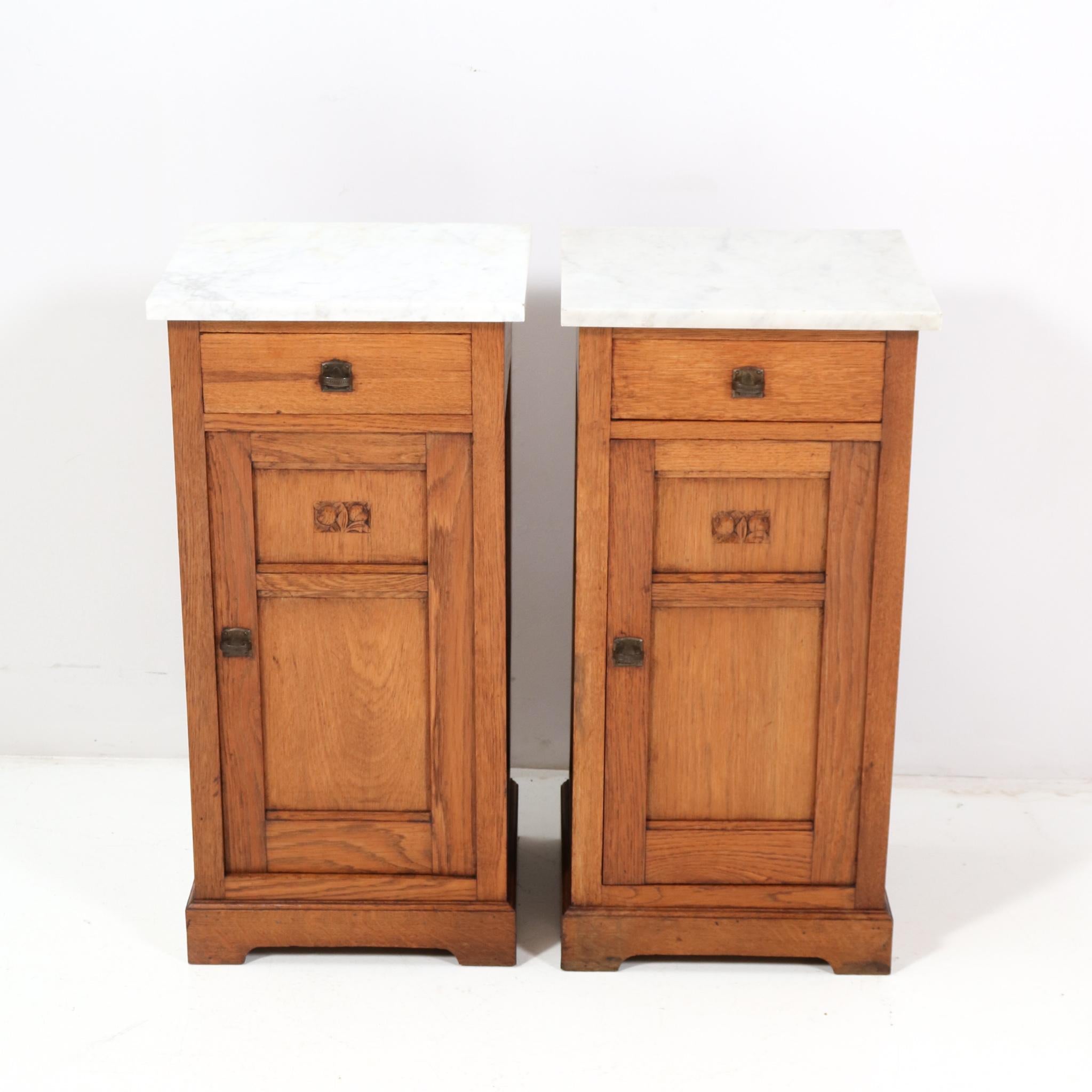Amazing and rare pair of Art Nouveau Jugendstil nightstands or bedside tables.
Striking Dutch design from the 1900s.
Solid oak with original patinated brass handles on doors and drawers.
Two original marble tops.
This wonderful pair of Art