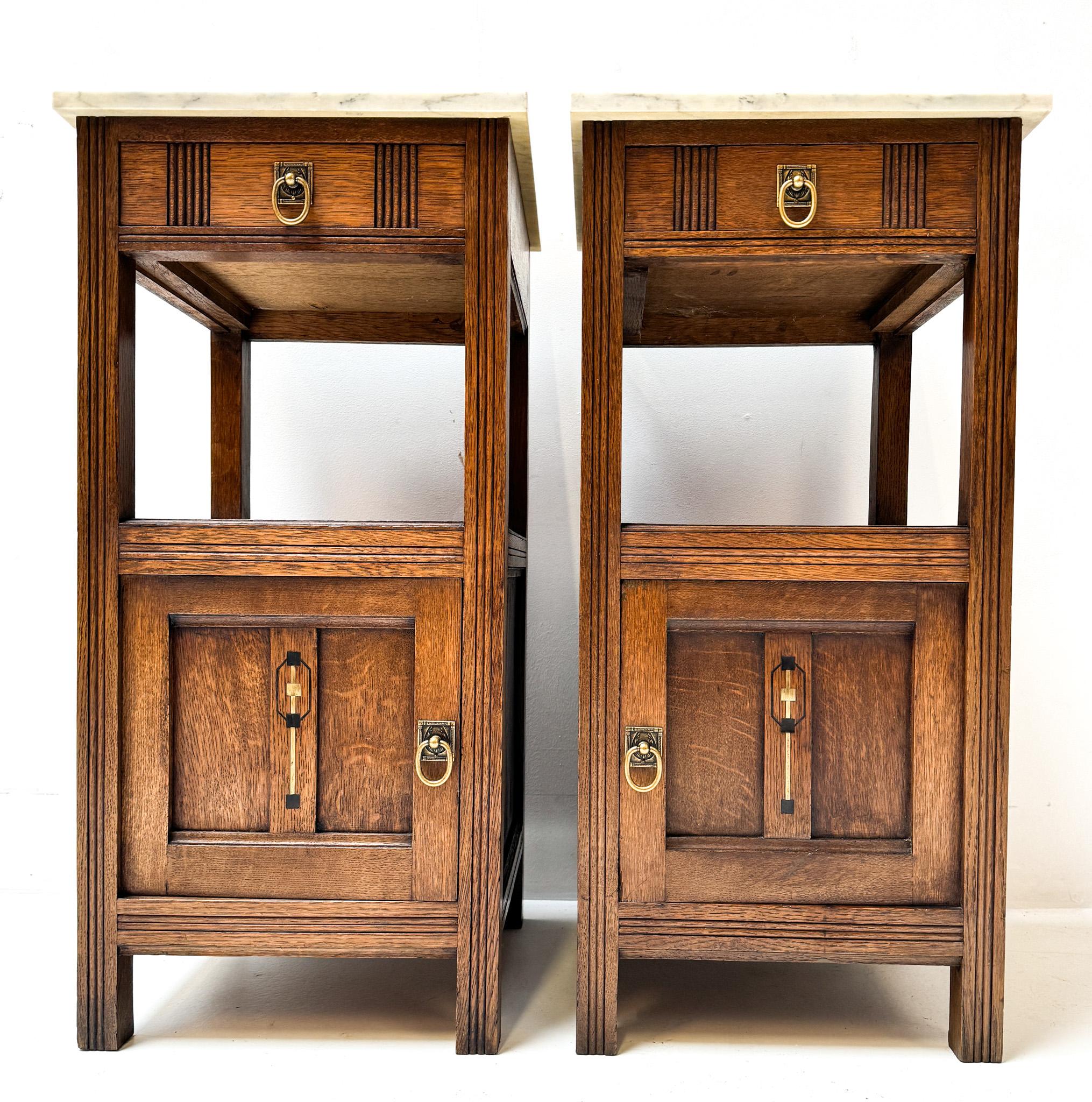 Stunning and elegant pair of Art Nouveau nightstands or bedside tables.
Striking French design from the 1900s.
Solid oak base with brass handles door and drawer.
Original white marble tops.
This wonderful pair of Art Nouveau nightstands or bedside