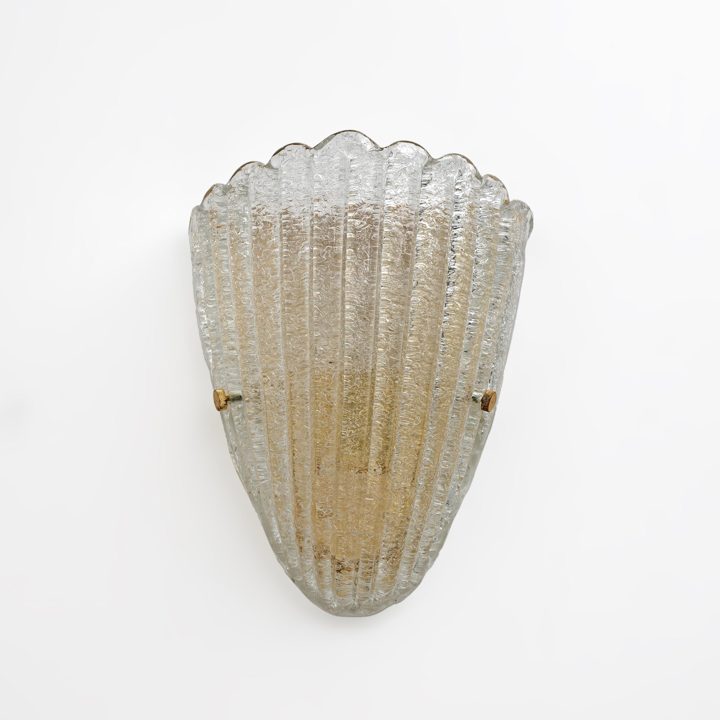 Two shell-shaped wall lamps, in Art Deco style, made in Italy by Barovier & Toso, 1960.
Made in Graniglia Murano glass, fixed on a lacquered metal and brass base.

The sconces have one light each and come with an E27 or E26 socket in the US.