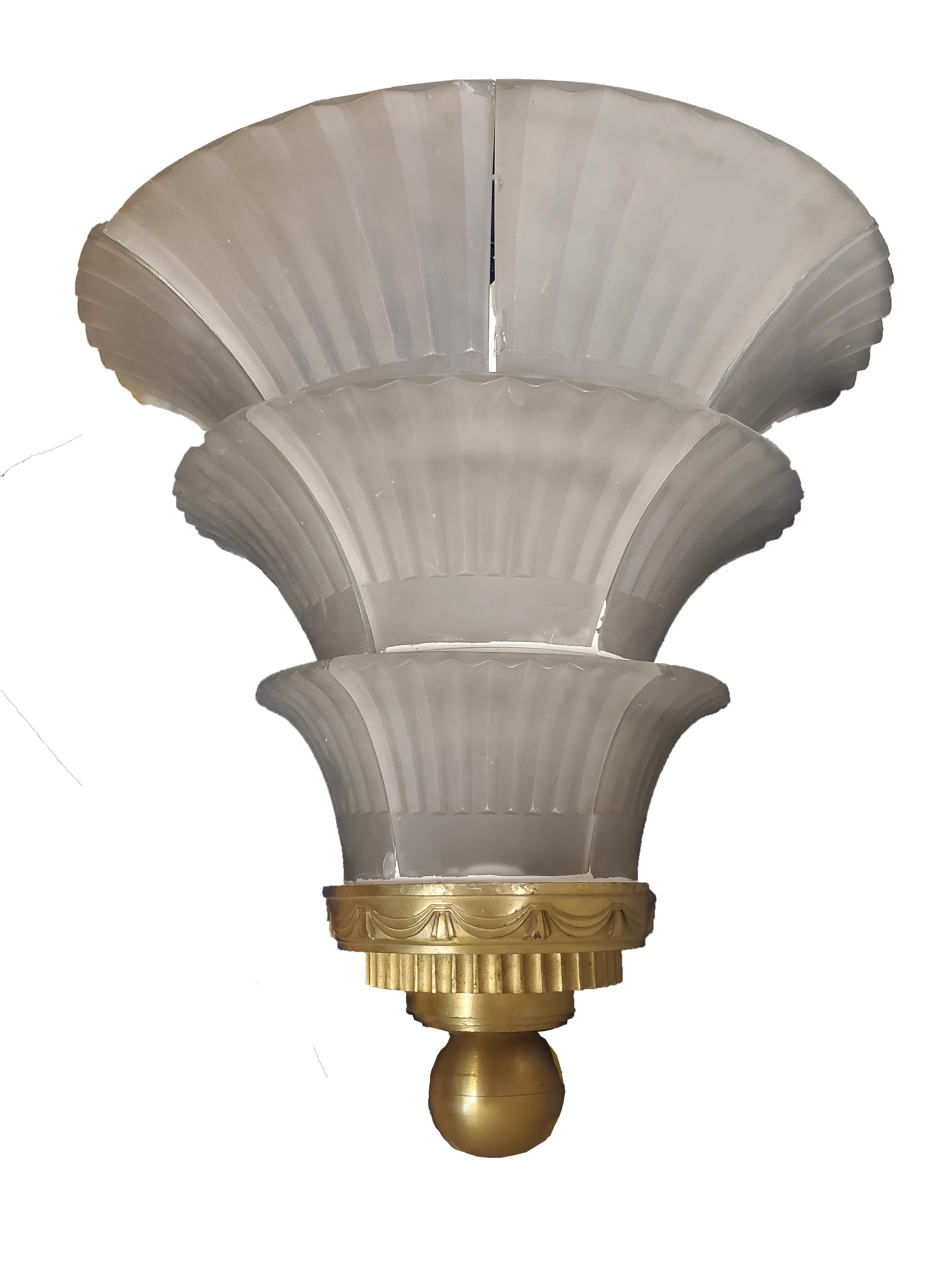These palatial and magnificent original French Art Deco sconces are truly a work of art. The elegant fluted design of the ten frosted art glass panels cascade down in three tiers, creating a stunning visual reminiscent of a waterfall. 
The