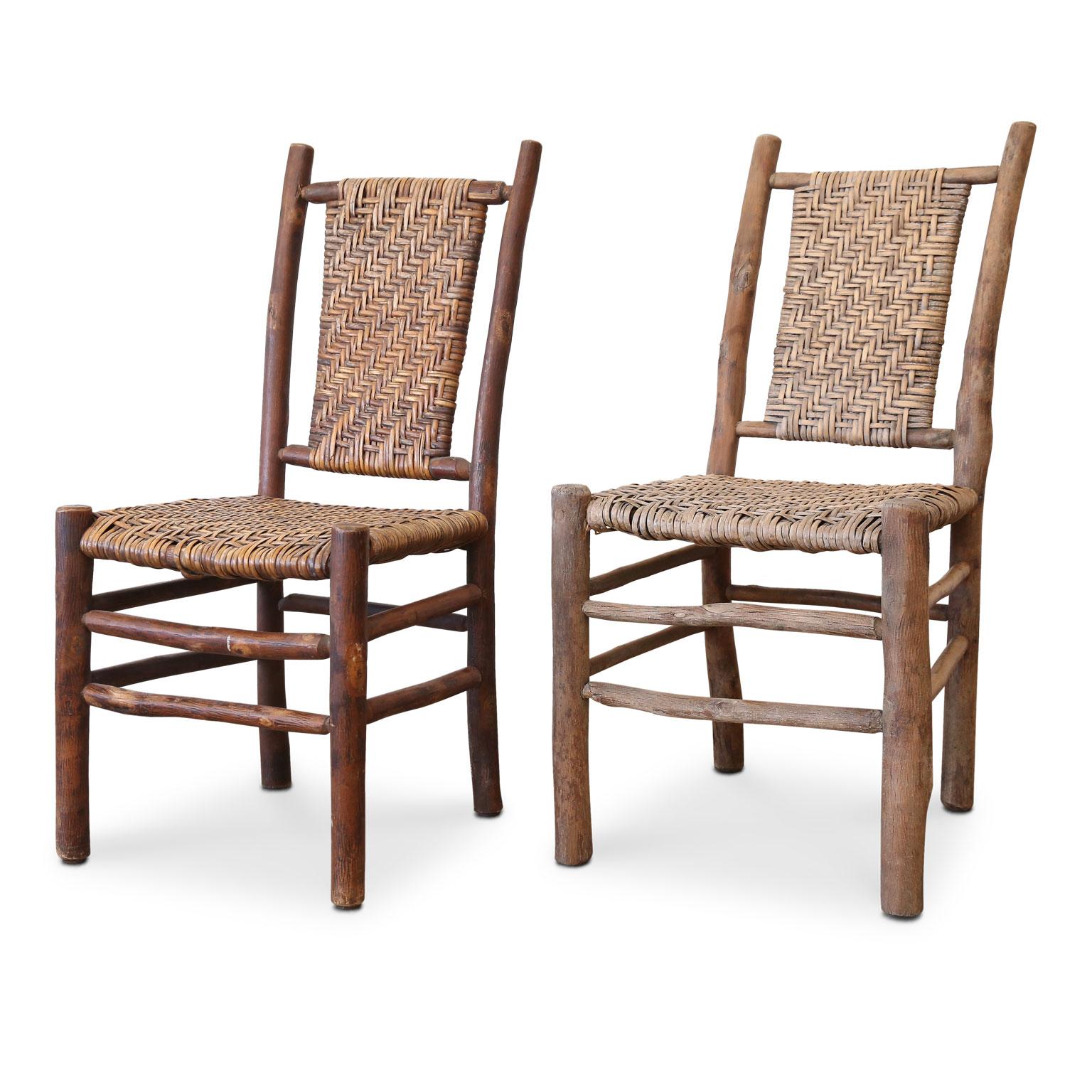 Two old hickory side chairs made of natural wood and exposed bark, with original handwoven seats and backs, and a beautiful subtle sun-bleached patina. Genuine Folk Art pieces signed and created, circa 1933-1942 for the Adirondack civilian