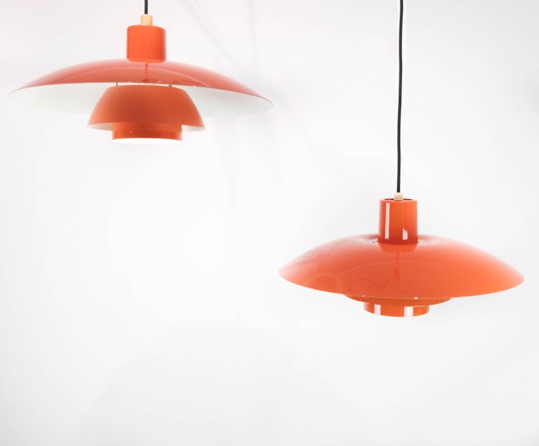 Two orange PH4 pendants designed by Poul Henningsen and manufactured by Louis Poulsen in the 1950s. The lamps are in great vintage condition.