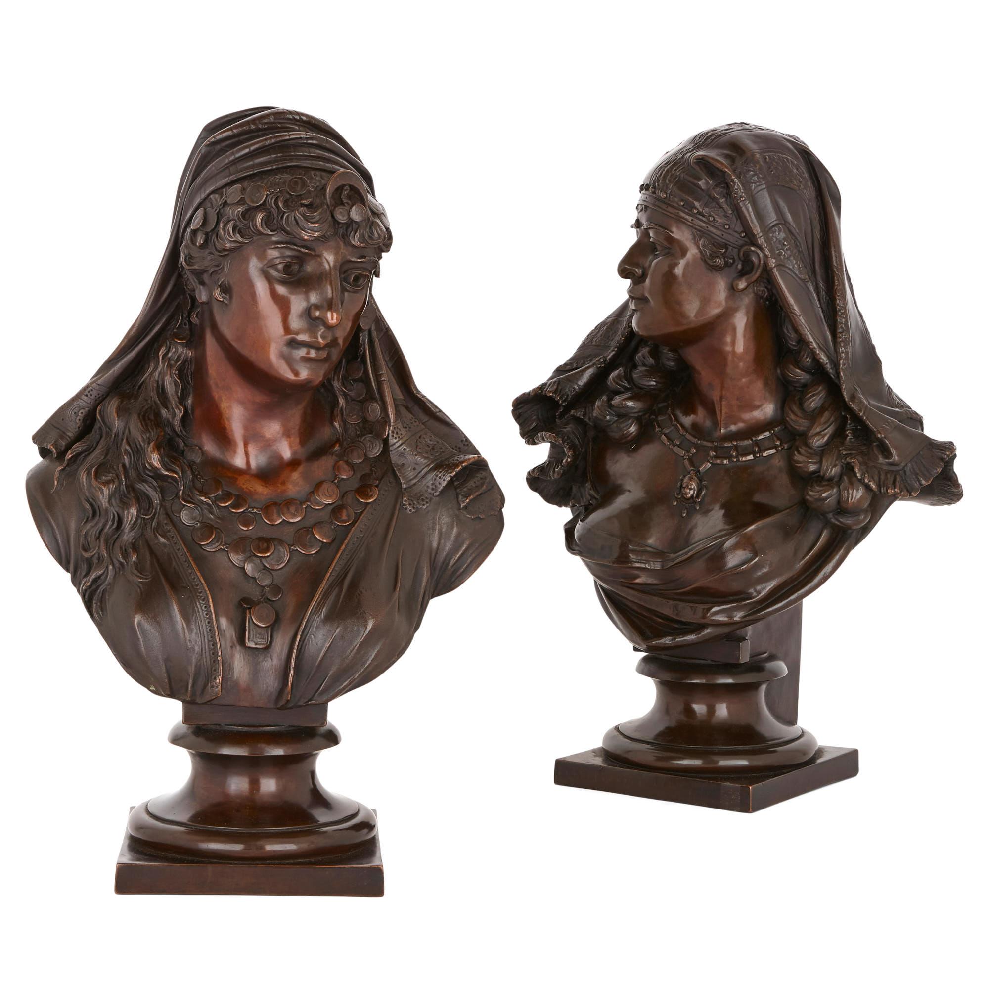 This busts in this pair of spelter sculptures take the form of two Orientalist female figures. The figures wear Orientalist clothing and are embellished with Orientalist-style jewelry about their necks and heads. The sculptures are delicately cast