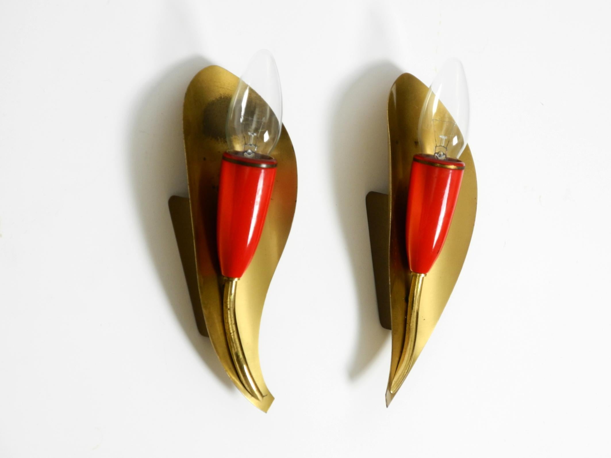 Deux belles lampes murales originales en laiton de style moderne du milieu du siècle.
Design/One typique des années 1950 en bon état.
Belle lumière à travers l'abat-jour en laiton.
L'ensemble de la lampe est en laiton. Les lampes rouges sont en