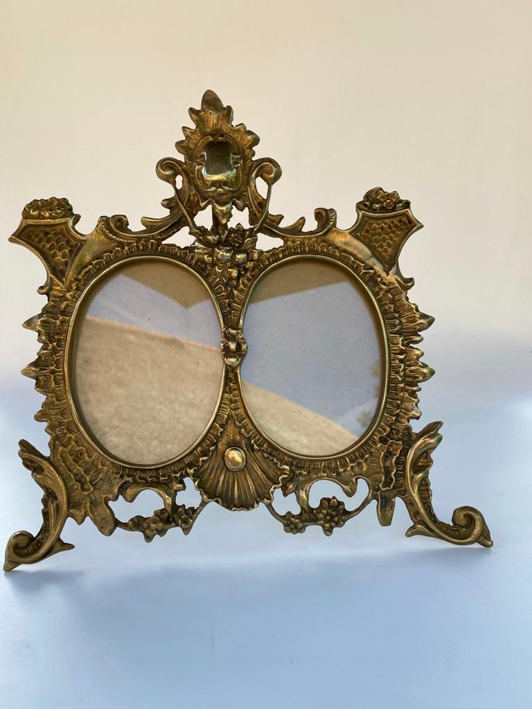 Two ornate heavy cast/brass double oval picture frames with easel back stand. 
Circa 1920. This is a beautiful original double oval picture frame from the early 1900's. It will hold pictures measuring up to 12 cm (4,72 inch) in height and 9 cm (3,54