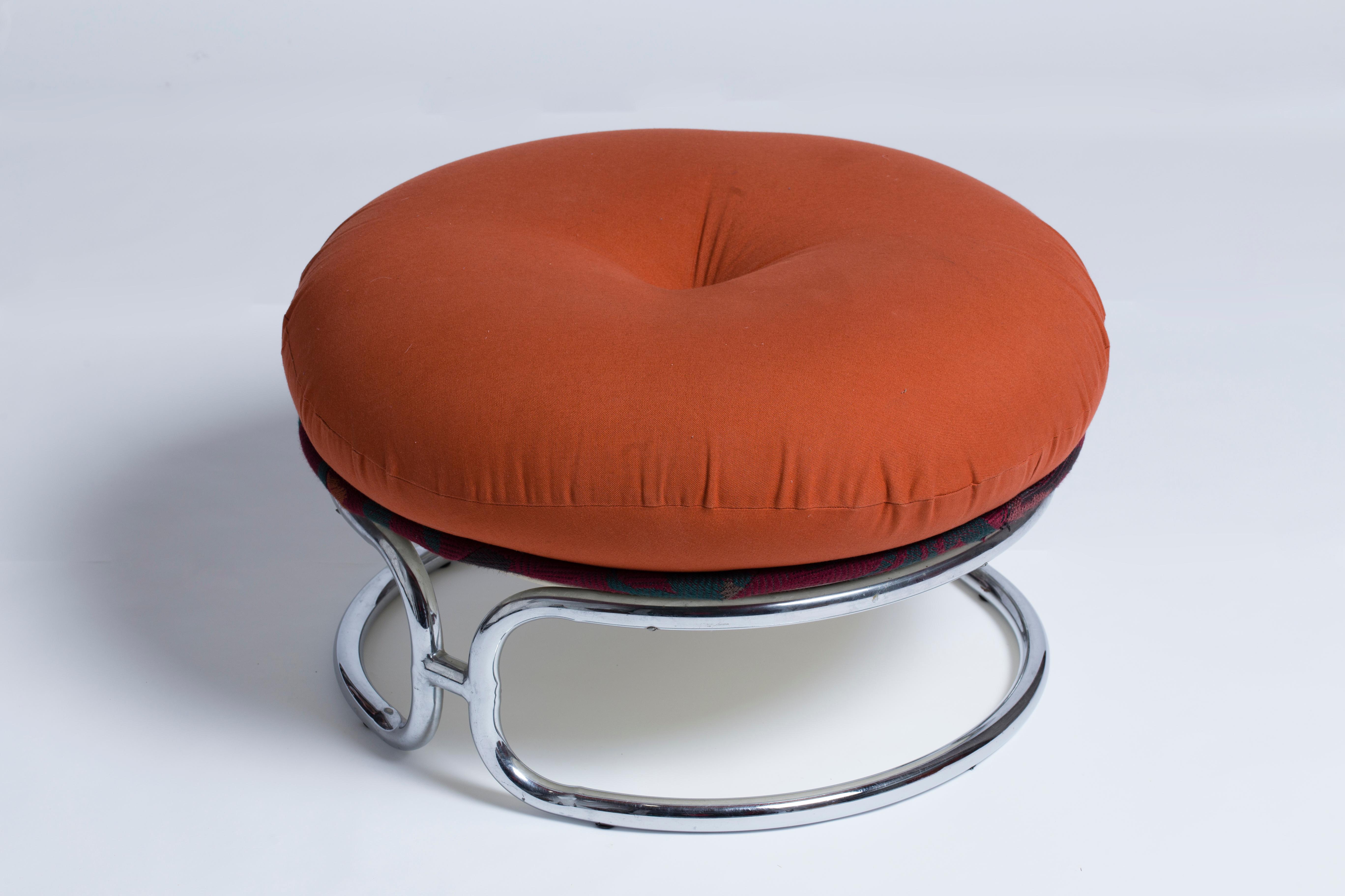 A pair of poufs in white fiberglass shell accommodating a fabric-covered cushion. 
Tubular chromed metal base forming two semi-circles connected to each other. 
Michel Cadestin, (1942).