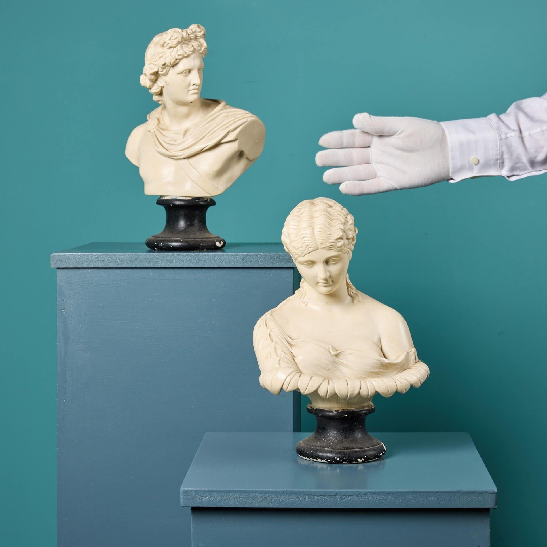 A pair of late 19th century painted plaster busts depicting figures of Greek Mythology, Apollo and Clytie. Made in plaster, these Clytie and Apollo bust sculptures are each painted and sit on a turned socle base. Together, these neoclassical style