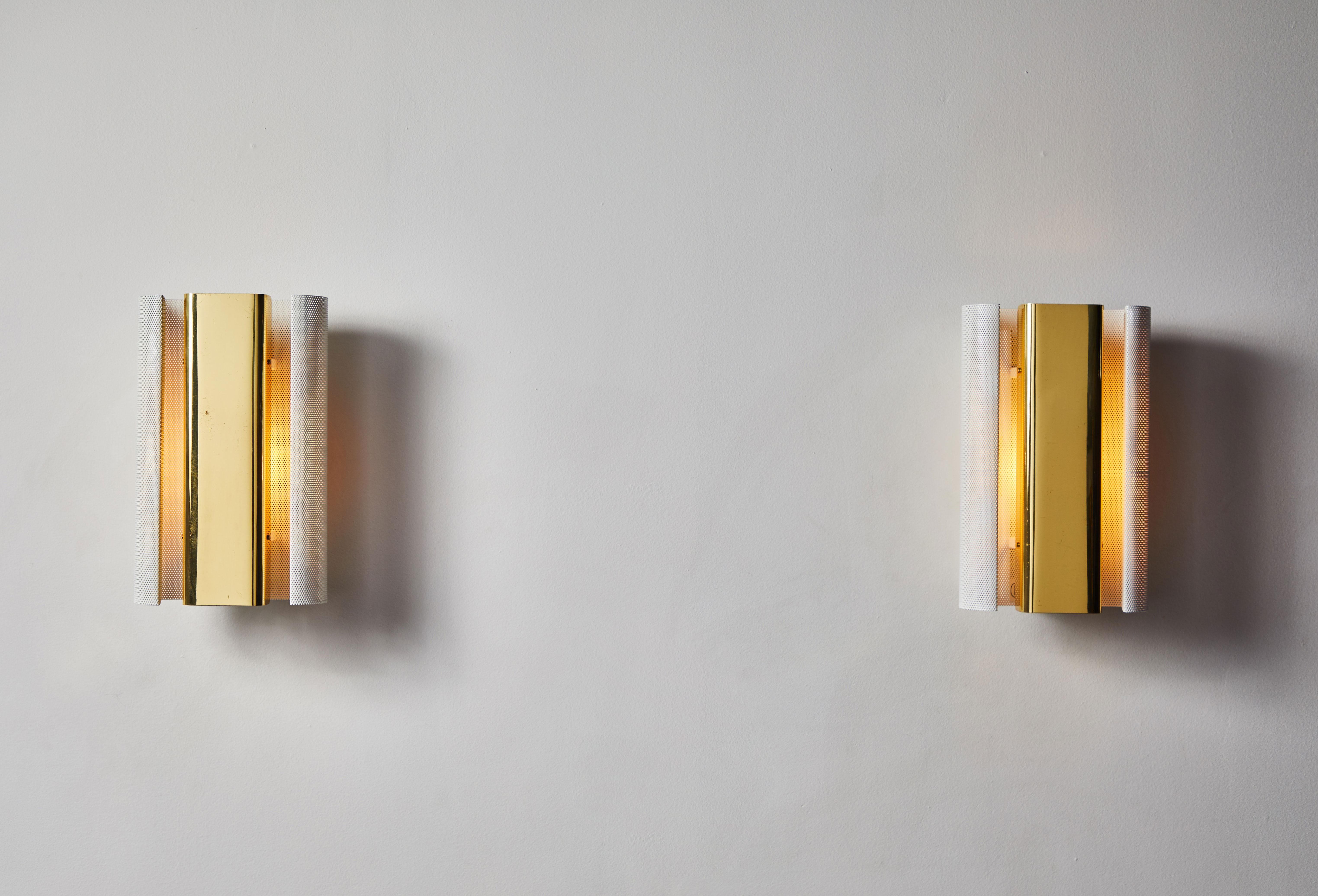 Two pair of sconces by Hans-Agne Jakobsson. Designed and manufactured in Sweden, circa 1970s. Perforated, enameled metal and brass. Deadstock, never used. Rewired for US junction boxes. Each light takes one E26 40w maximum bulb. Sold as pairs only.