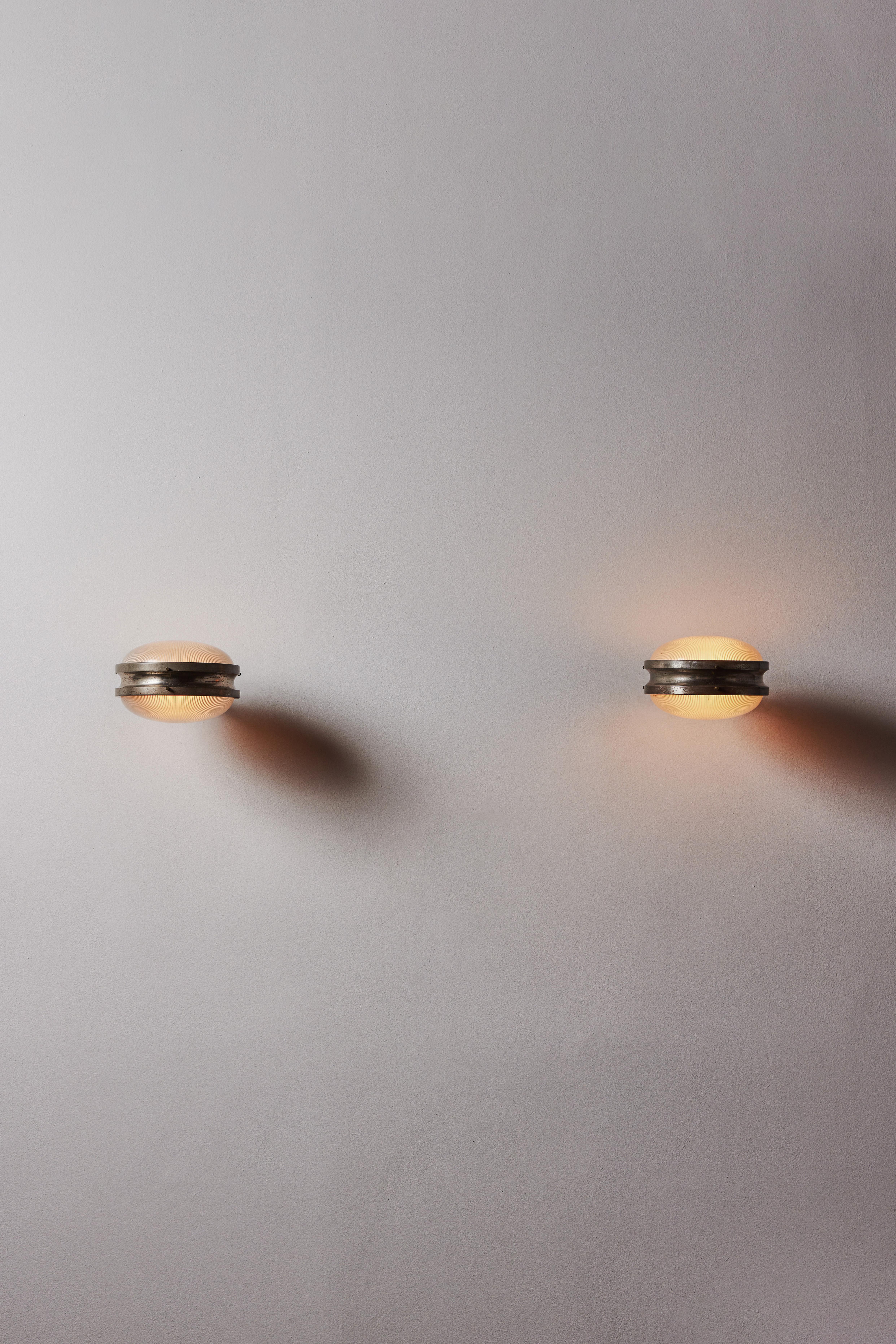 Pair of sconces by Sergio Mazza. Designed and manufactured in Italy, circa 1960s. Patinated nickel, Holophane glass. Custom backplates. Rewired for U.S. standards. We recommend 1 e27 60w maximum bulb per sconce. Bulbs provided as a one time