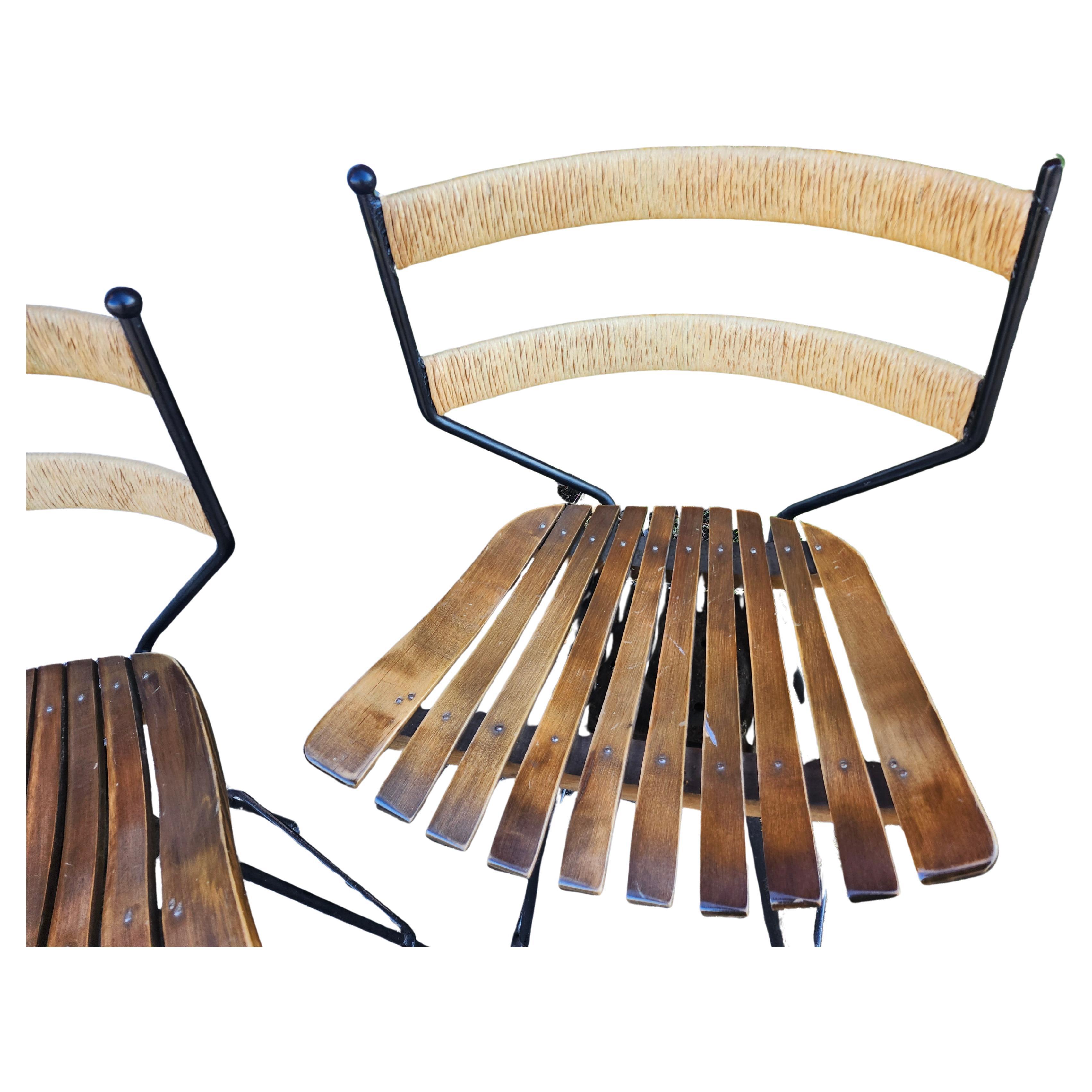 Fabulosos taburetes de bar o mostrador vendidos por parejas por Arthur Umanoff C1960. De hierro pintado de negro, con asientos de arce lacado y respaldos de rafia de diseño curvo. Todas son giratorias y están en excelente estado vintage, con un