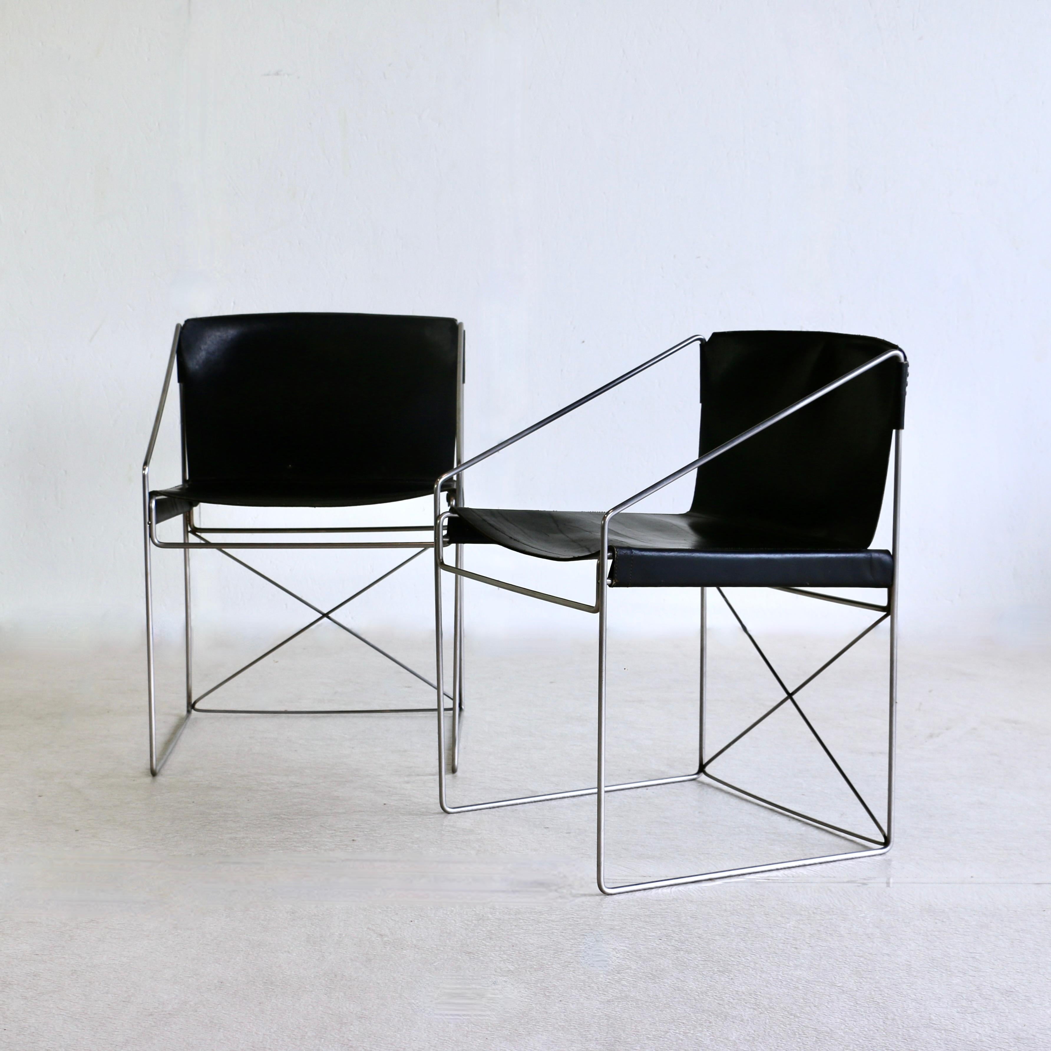 Two pairs of armchairs with matt chromed iron legs and black leather seats. Italy, 1980s.