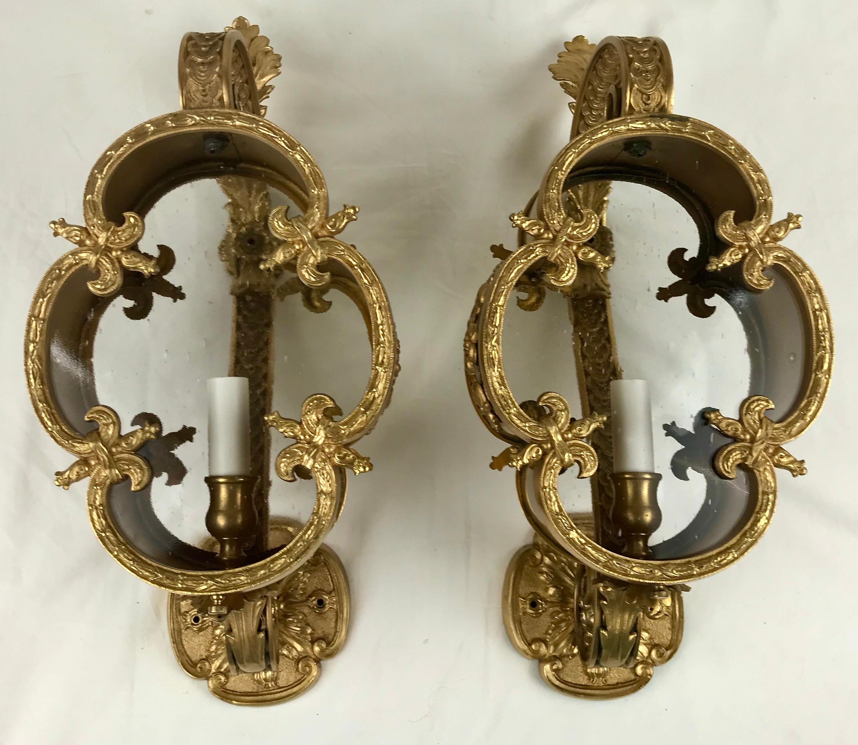 Diese wandmontierten Laternen aus vergoldeter Bronze sind wunderschön detailliert und verfügen über mundgeblasene Glasscheiben auf der Vorder- und Rückseite. Sie wurden neu verkabelt und sind sofort einsatzbereit.