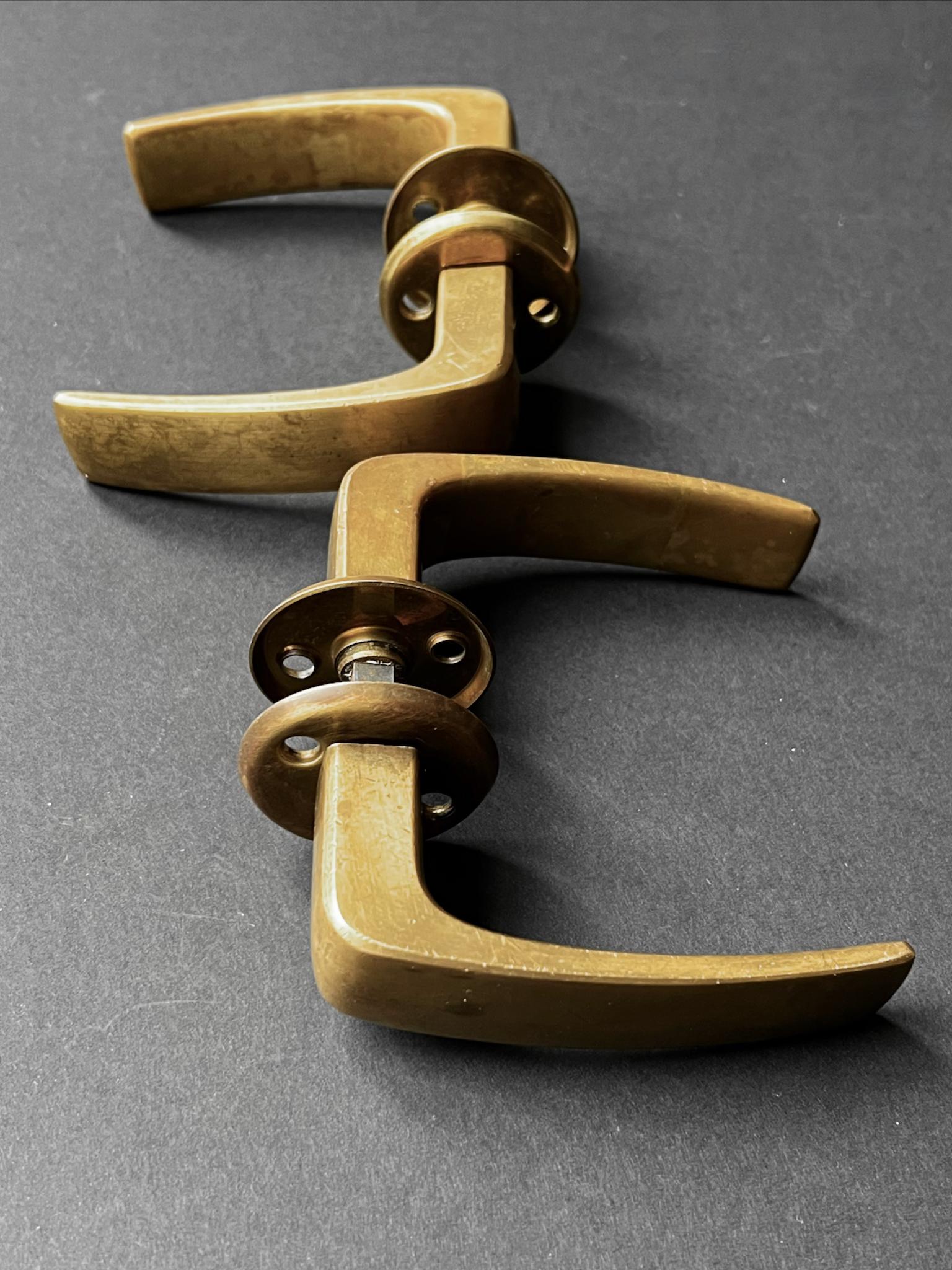 Deux paires de poignées de porte à levier en laiton finlandais avec rosettes. Seconde moitié du XXe siècle, attribuée à Primo/One dont les concepteurs étaient notamment l'architecte Heikki Siren et Timo Sarpeneva.

Un beau design lourd en bon état