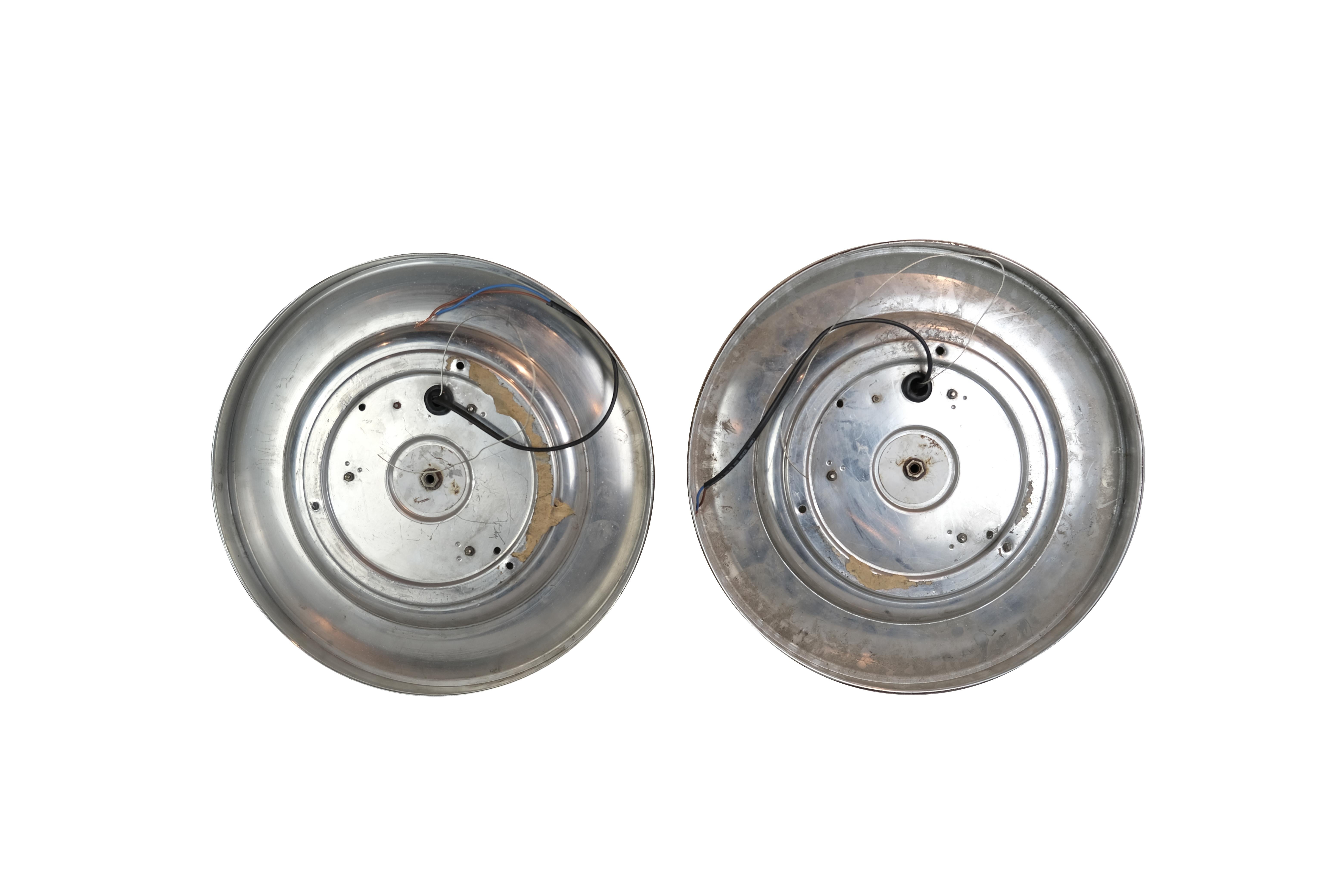 Two Pairs of round disk French wall sconces or ceiling lights with a geometric patterned convex molded glass shade surrounded by a brass rim. Each pair is priced separately. Each fixture has three sockets.

Second pair of round disk sconces or