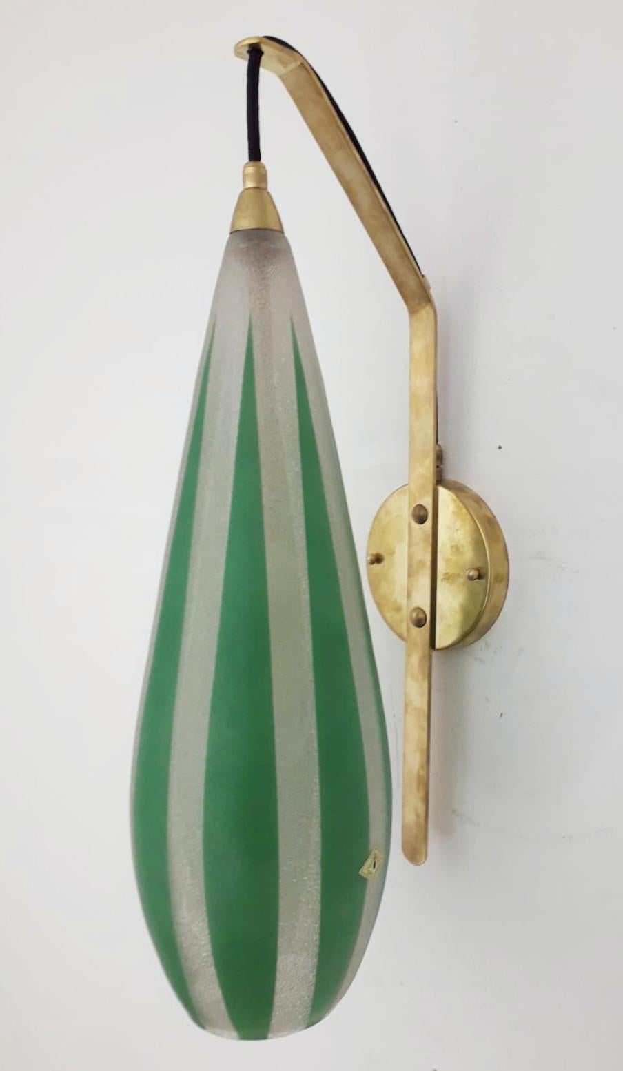 Vintage wall light consisting of a large glass diffuser with green stripes, suspended with a cable from a brass frame / Made in Germany by Das Licht, circa 1960s
Original sticker on the glass
1 light / E12 or E14 type / max 40W
Measures: Height 20