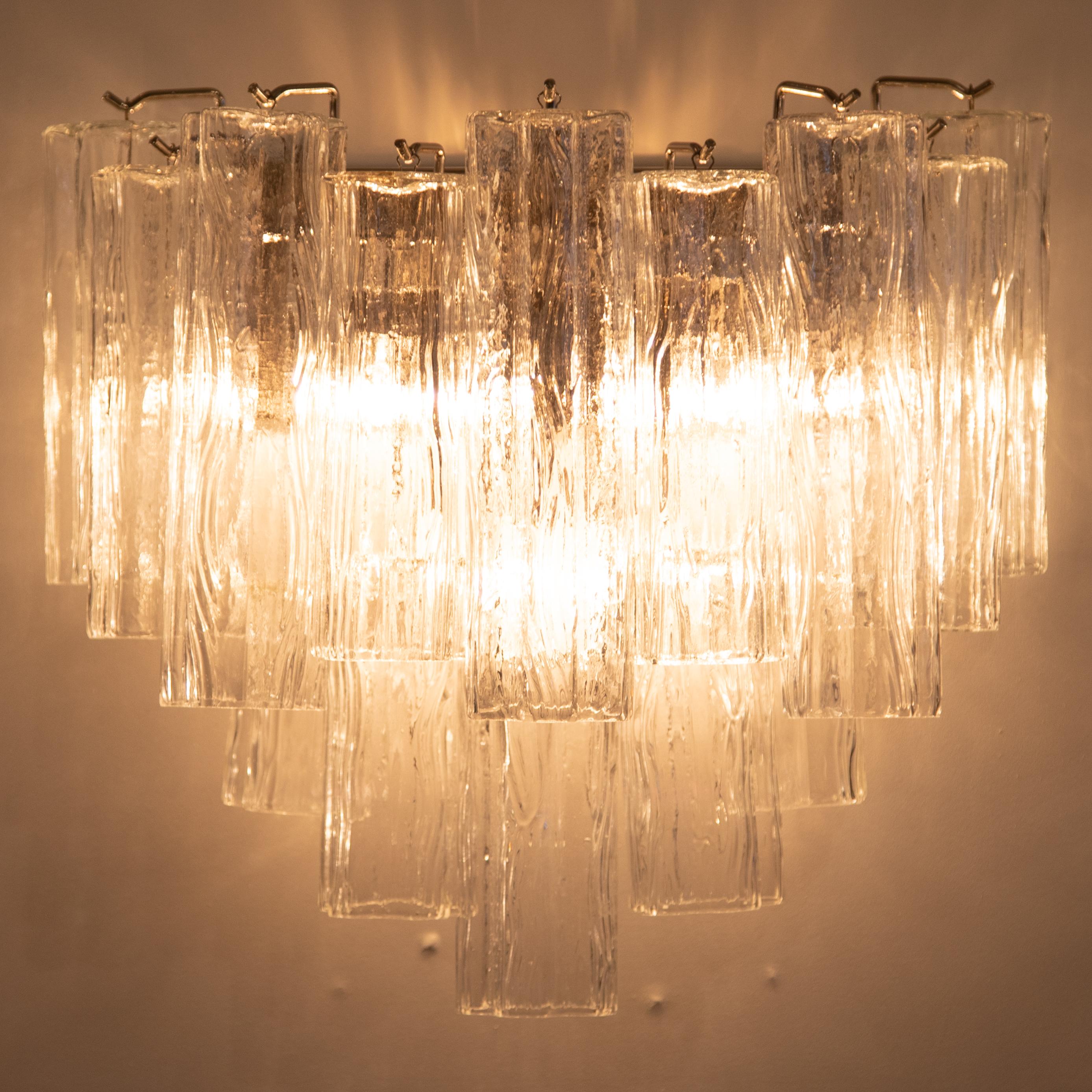 Large Murano sconces feature two rows of cascading tronchi-shaped crystals supported by a polished-nickel frame with six candelabra-based bulbs. 14 crystals each, including three 10-inch crystals and six 8-inch crystals, that are hung at staggered