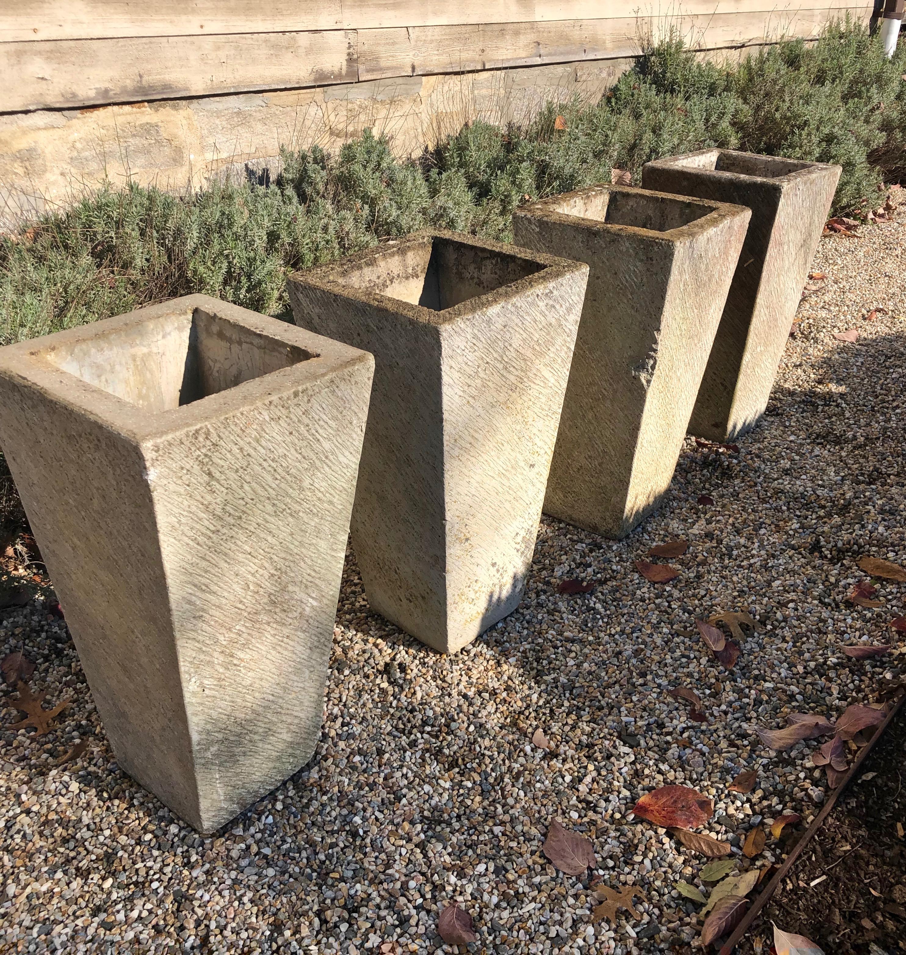 We love the sleek, tall and narrow canted form of these English cast stone planters that feature a warm, pale, lightly-weathered surface with heavier weathering to the tops. In overall very good vintage condition, three of four have some minor