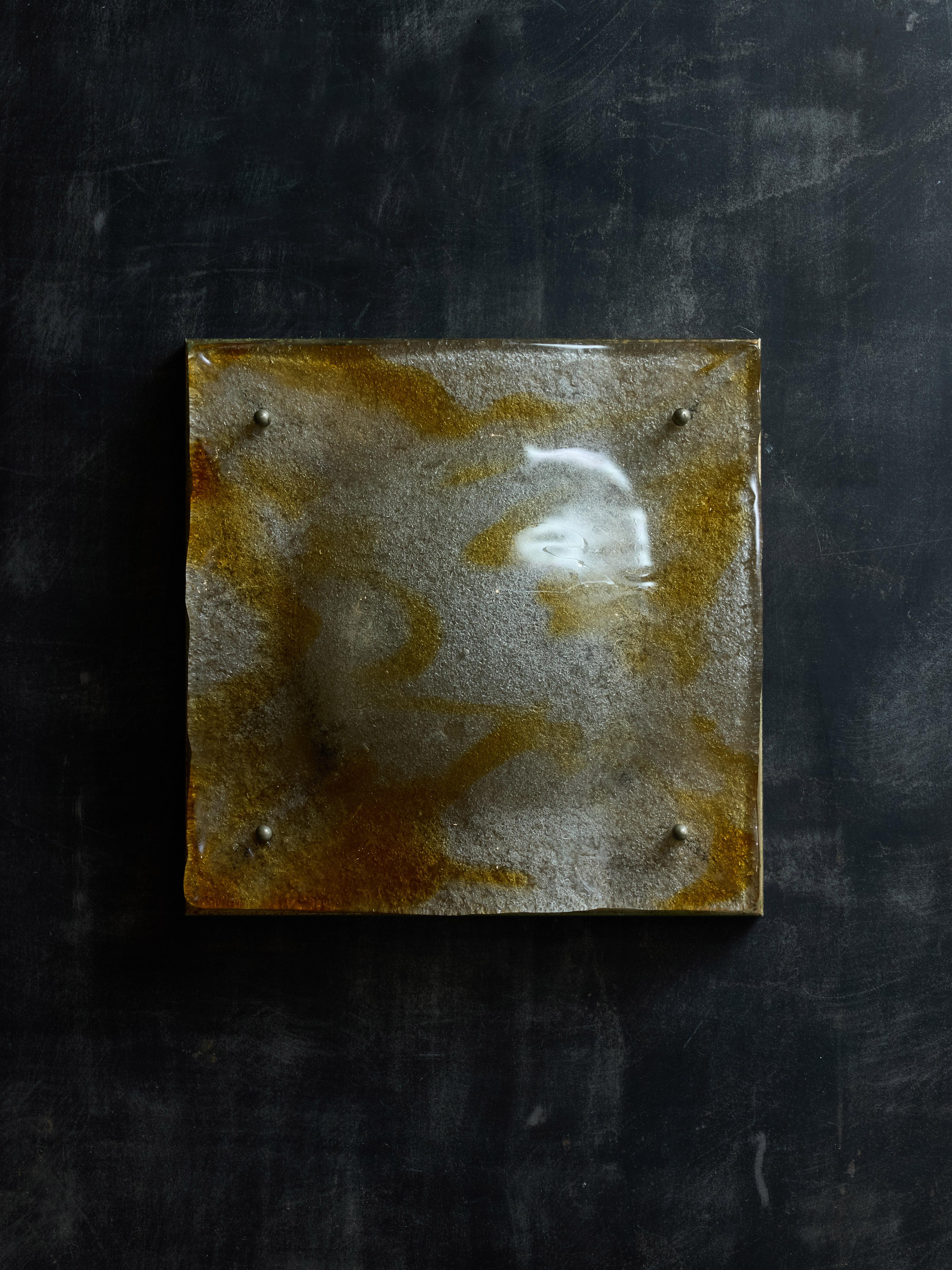 Dos pares de apliques de pared diseñados por Toni Zuccheri para Mazzega en la década de 1970.
Estos apliques están formados por una placa trasera cuadrada oxidada que alberga dos fuentes de luz, cubiertas por  un panel de cristal de Murano texturado