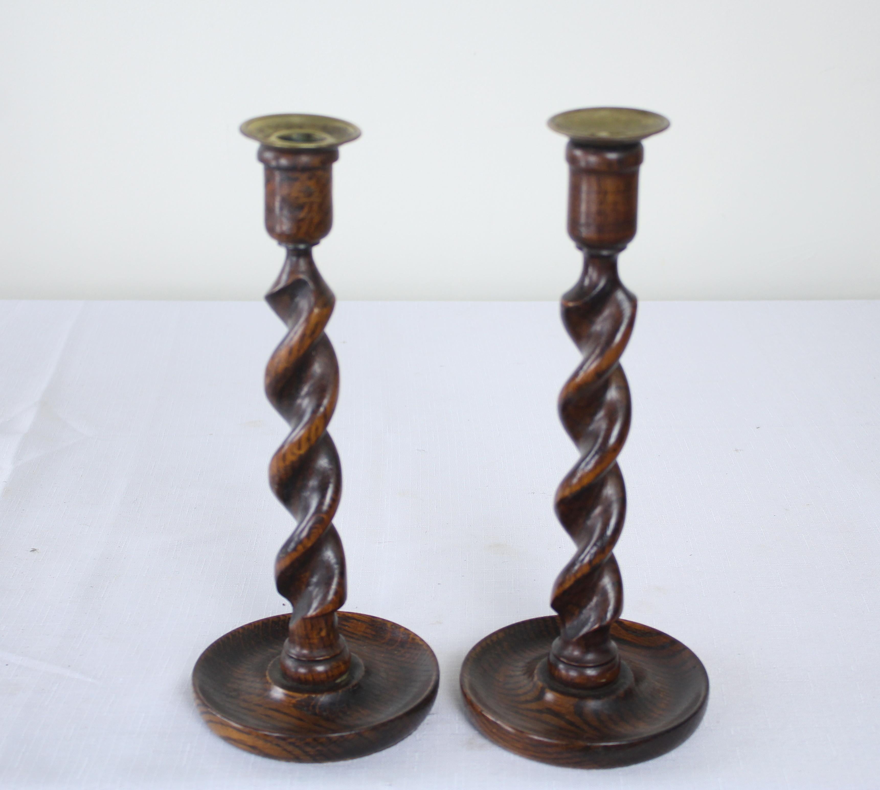 Two pairs of oak candlesticks, England, circa 1900. Heights vary from 11.25-12