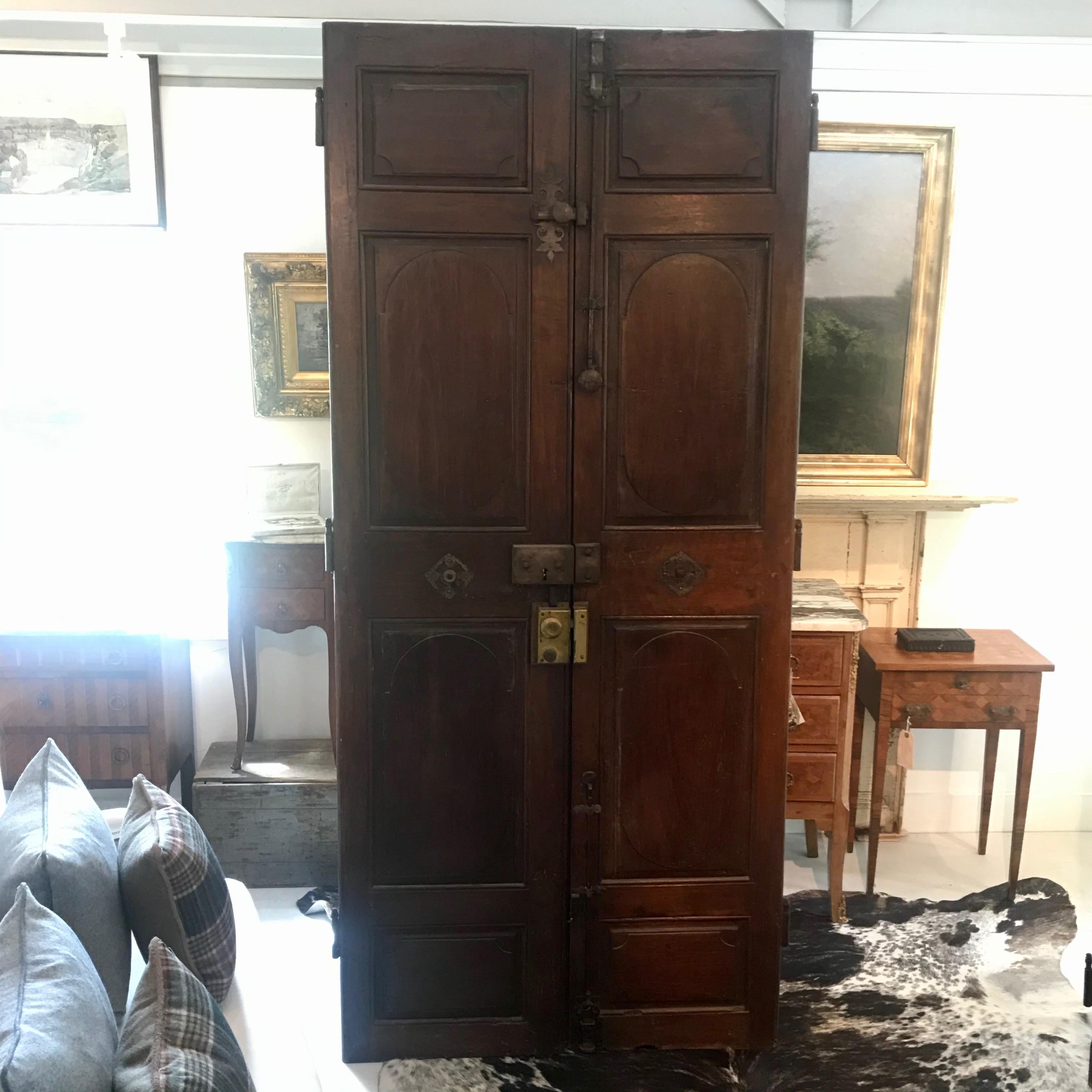Two pairs of matching French walnut interior doors retaining all of the original gorgeous French bronze hardware. These striking tall double pairs of doors wear their age with grace, and are in great shape. One side of one of the pairs of doors is