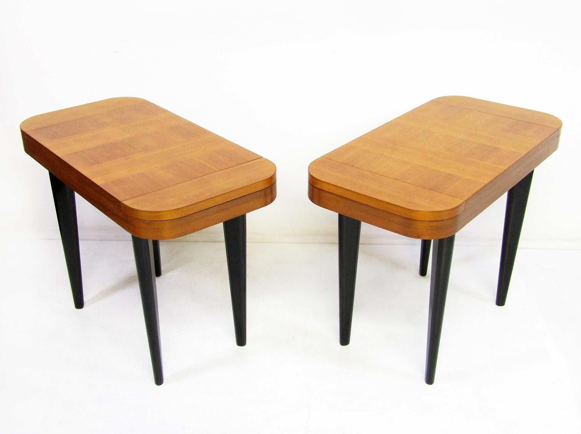 A pair of Art Deco end tables or nightstands by Gilbert Rohde for Herman Miller, circa 1940.

Made from striking cross-banded Paldao wood on ebonised legs, each table has two discretely lidded storage compartments for jewellery or other small