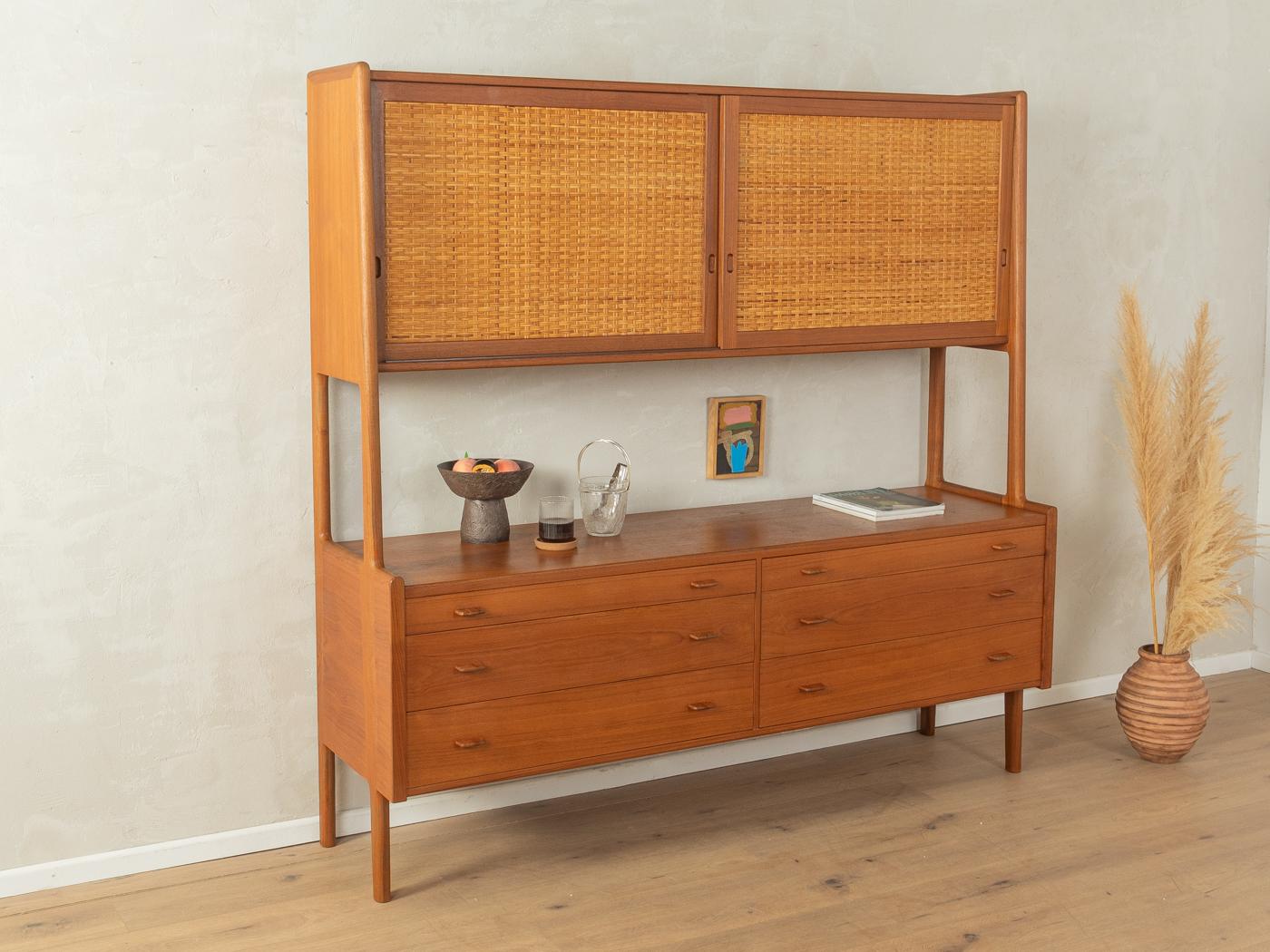 Classic highboard by Hans J. Wegner for Ry Møbler from the 1950s. Model Ry 20. Corpus in teak veneer with two sliding doors with woven wicker, five shelves, six drawers and feet typical of the time.

Quality Features:
accomplished design: perfect