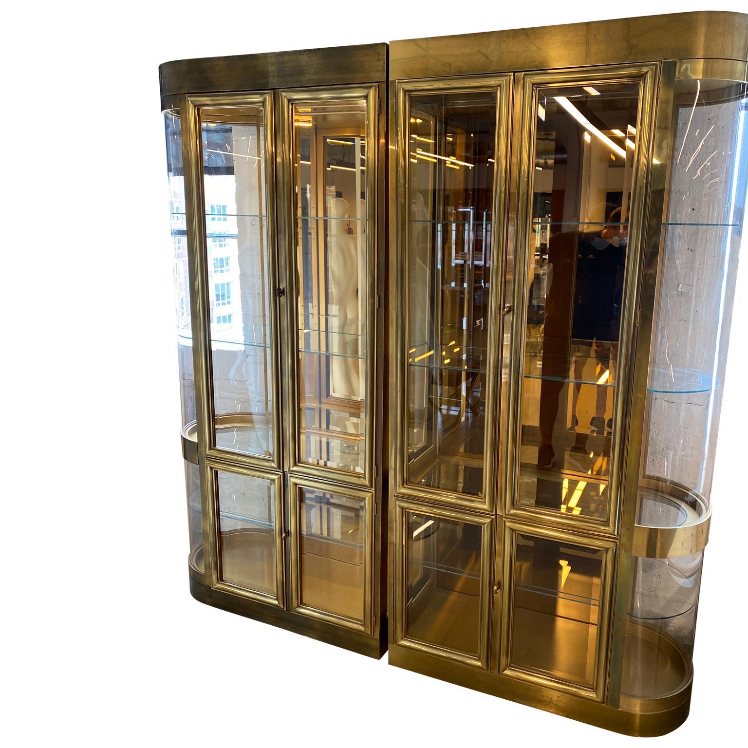 Four sets of two part Mastercraft designed curved brass and glass vitrines or display cabinet

This collection of 4 sets of Mastercraft brass vitrines or display cabinets all has curved Lucite sides and with mirrored back, glass shelves and