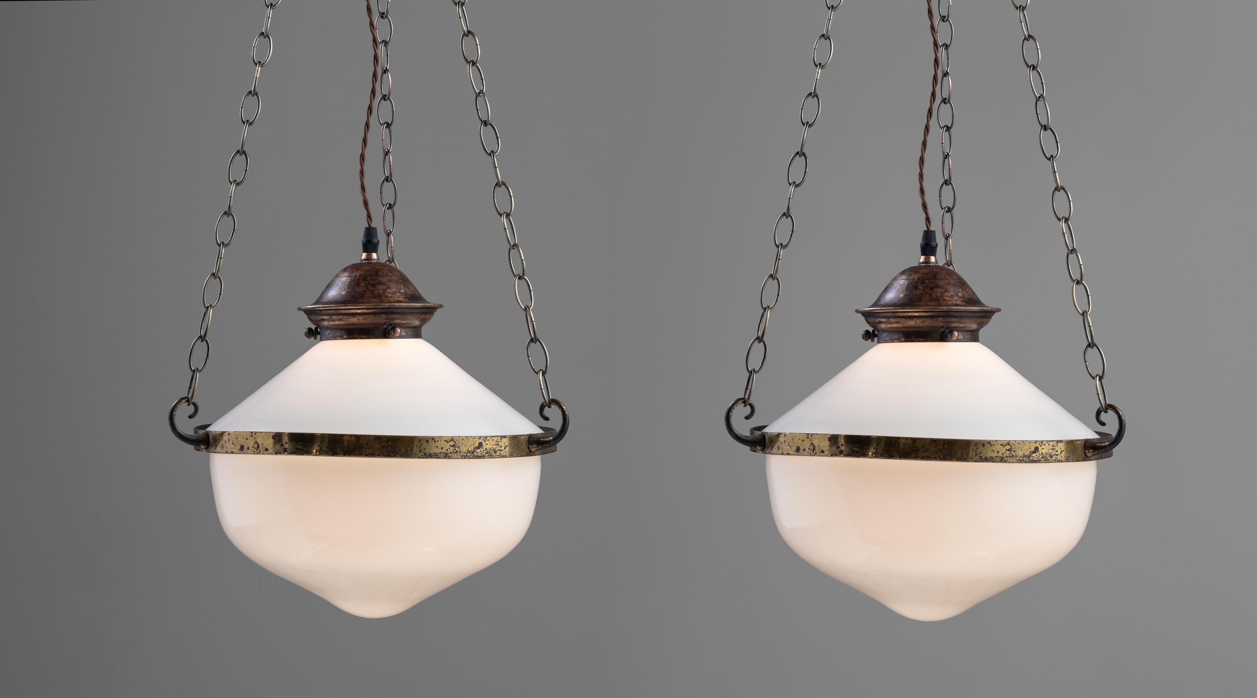 Two part opaline suspension lamps, England circa 1930

Two opaline shades with brass central band and chains running up to a brass 4-way hook.