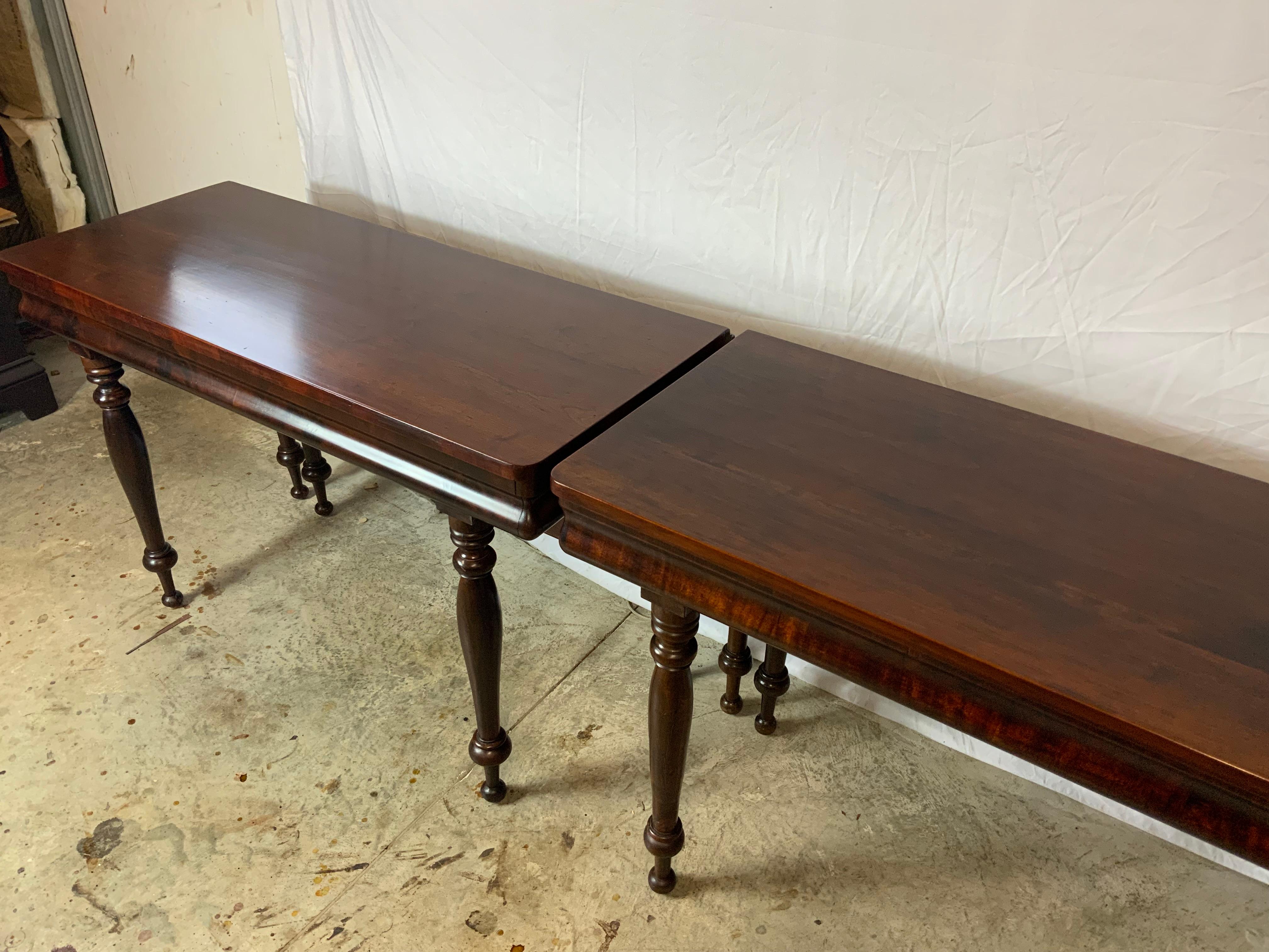 A nice wide mid 19th century Sheraton two part banquet table with solid Cherry tops and legs with Mahogany veneered ogee aprons on the fronts. A fifth swing leg holds the drop leaf tops that are held tightly together with table yokes. Very nice