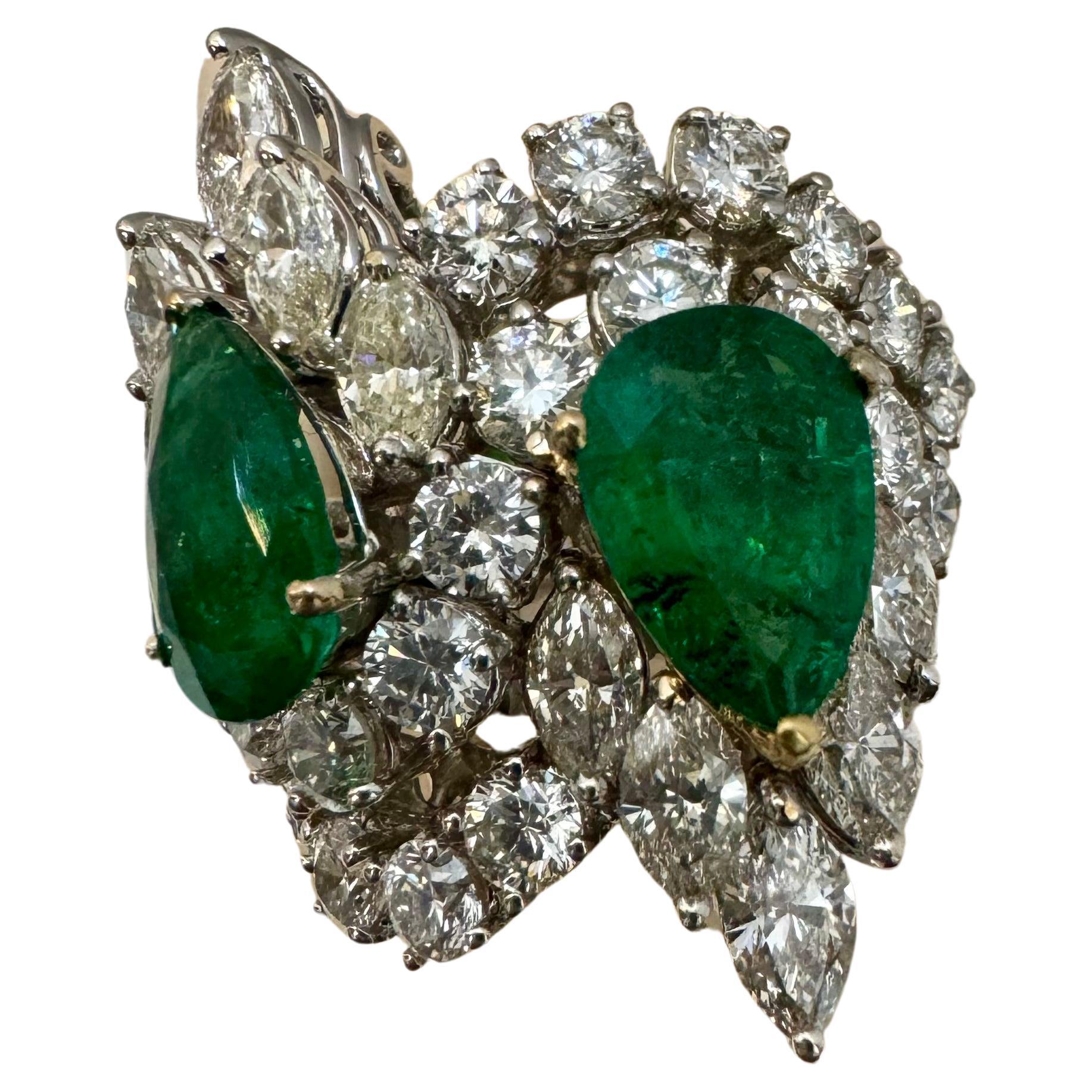 Voici notre exquise bague en or blanc 18 carats, ornée de deux magnifiques émeraudes naturelles de Zambie en forme de poire et de 8,75 carats de diamants. Cette bague est vraiment remarquable, mettant en valeur la beauté de l'émeraude et l'éclat des
