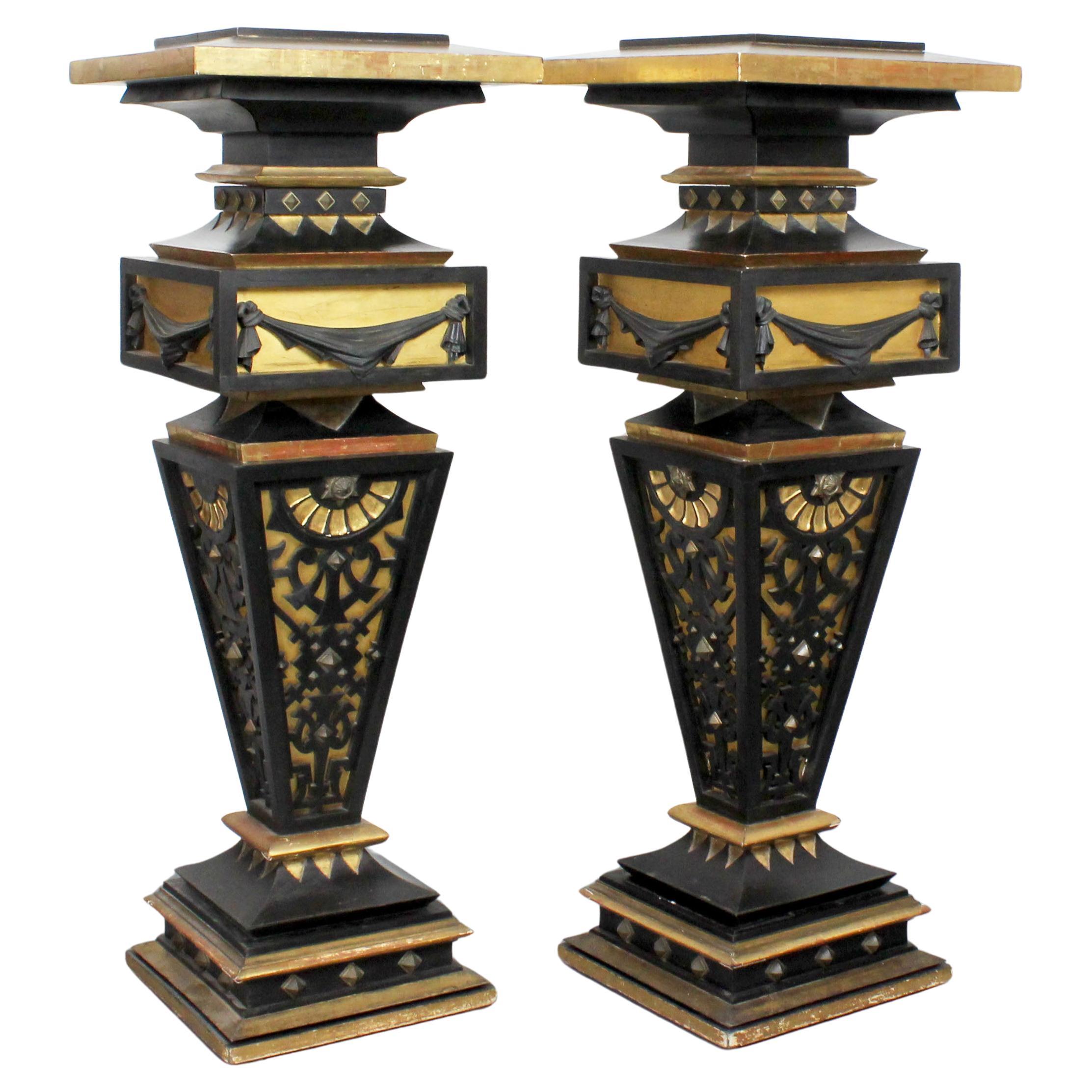 Two pedestals made of wood, gilded and painted black with details in gold bronze For Sale