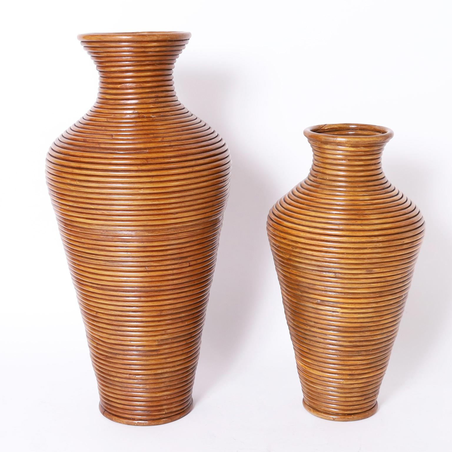 Two chic mid-century floor vases or urns crafted in pencil reed in classic modern form. Priced individually.

Taller vase: H: 36 DM: 16 $2,250.00

Shorter vase: H: 27 DM: 14 $1,500.00.