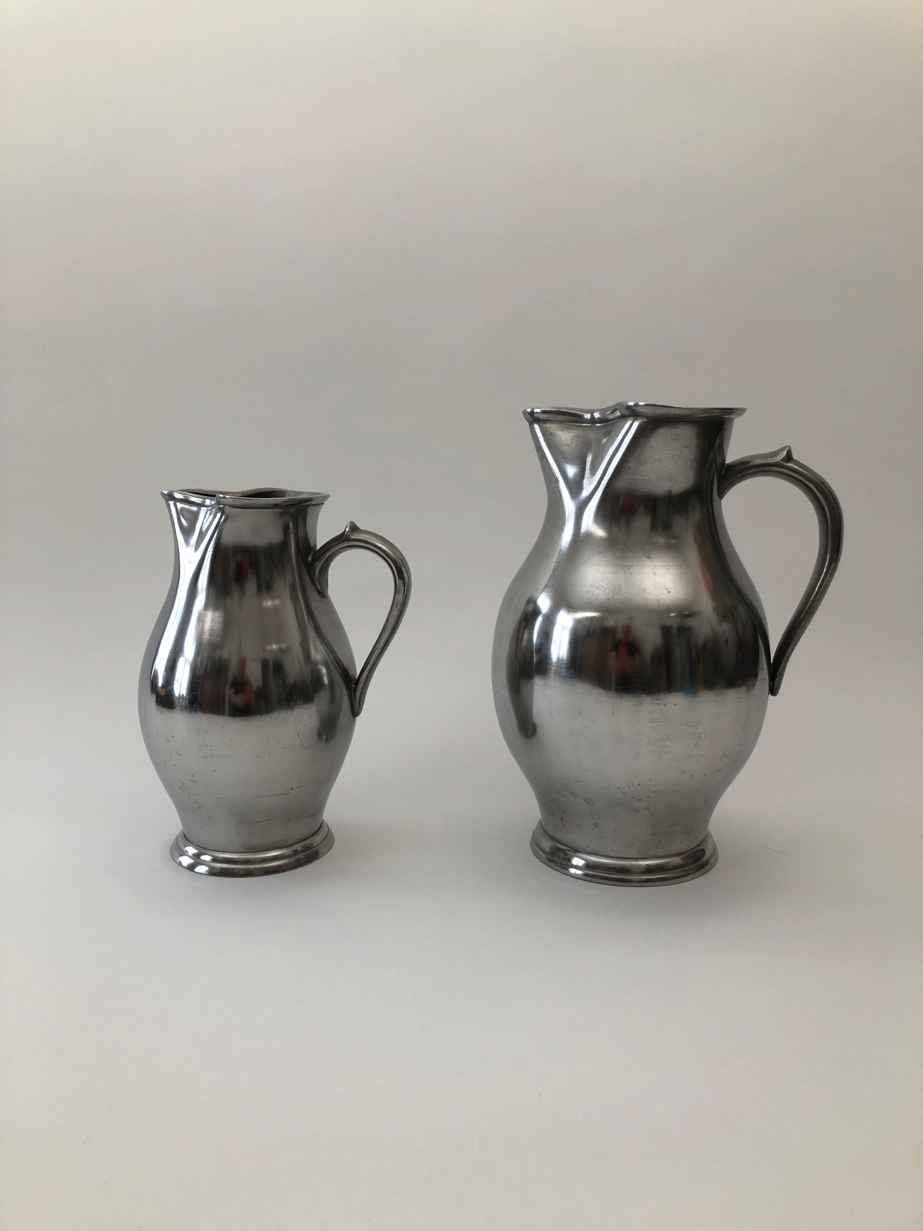 A set of two pewter wine jugs from the Wiener Zin manufacture ,dated 1837. These polished pewter wine jugs exhibit beautiful flowing forms
that emphasis the visual softness of pewter. I have photographed these objects in another setting,