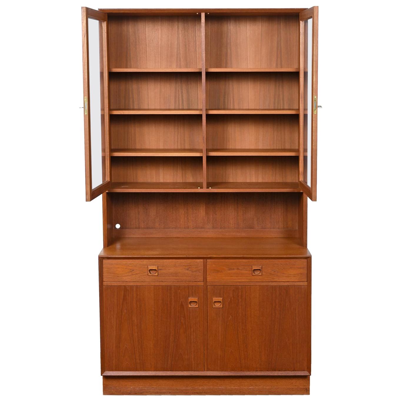 Exceptional two-piece bookcase cabinet hutch with carved teak pulls by Brouer Møbelfabrik. The craftsmanship is exquisite and the original owner treated this piece like a jewel. It is in excellent overall condition and only required moderate