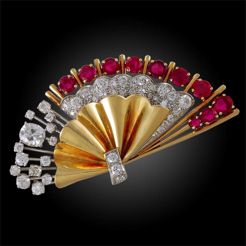 A retro two piece brooch designed as fans, crafted in 18k yellow gold, accentuated with brilliant diamonds and rubies. This exceptional piece dates back to the 1940s. 