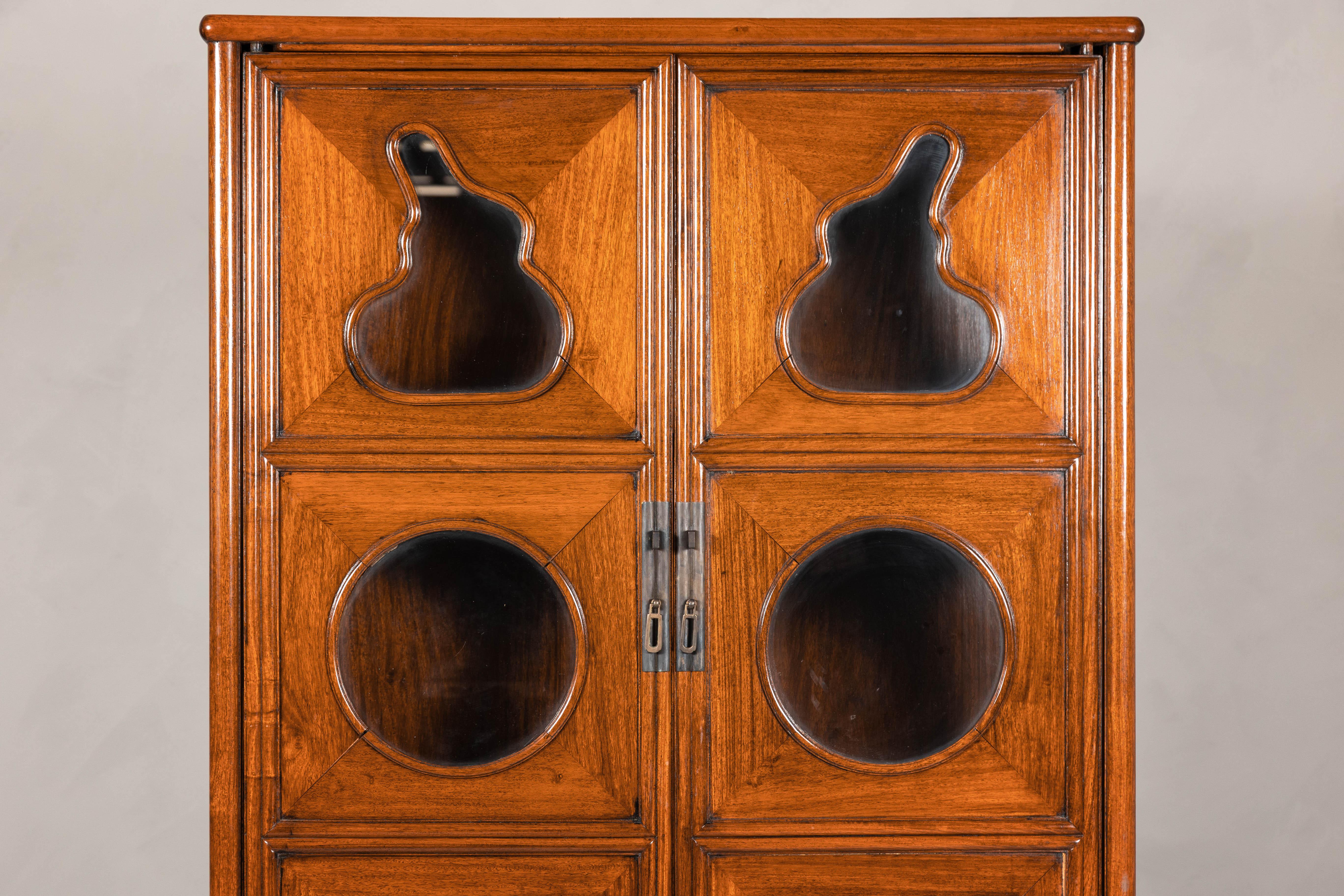 Esta vitrina china combina a la perfección arte y funcionalidad, con intrincados paneles de cristal tallado dentro de un rico marco de madera noble. Su diseño, una interpretación moderna de los muebles tradicionales de los eruditos, incorpora